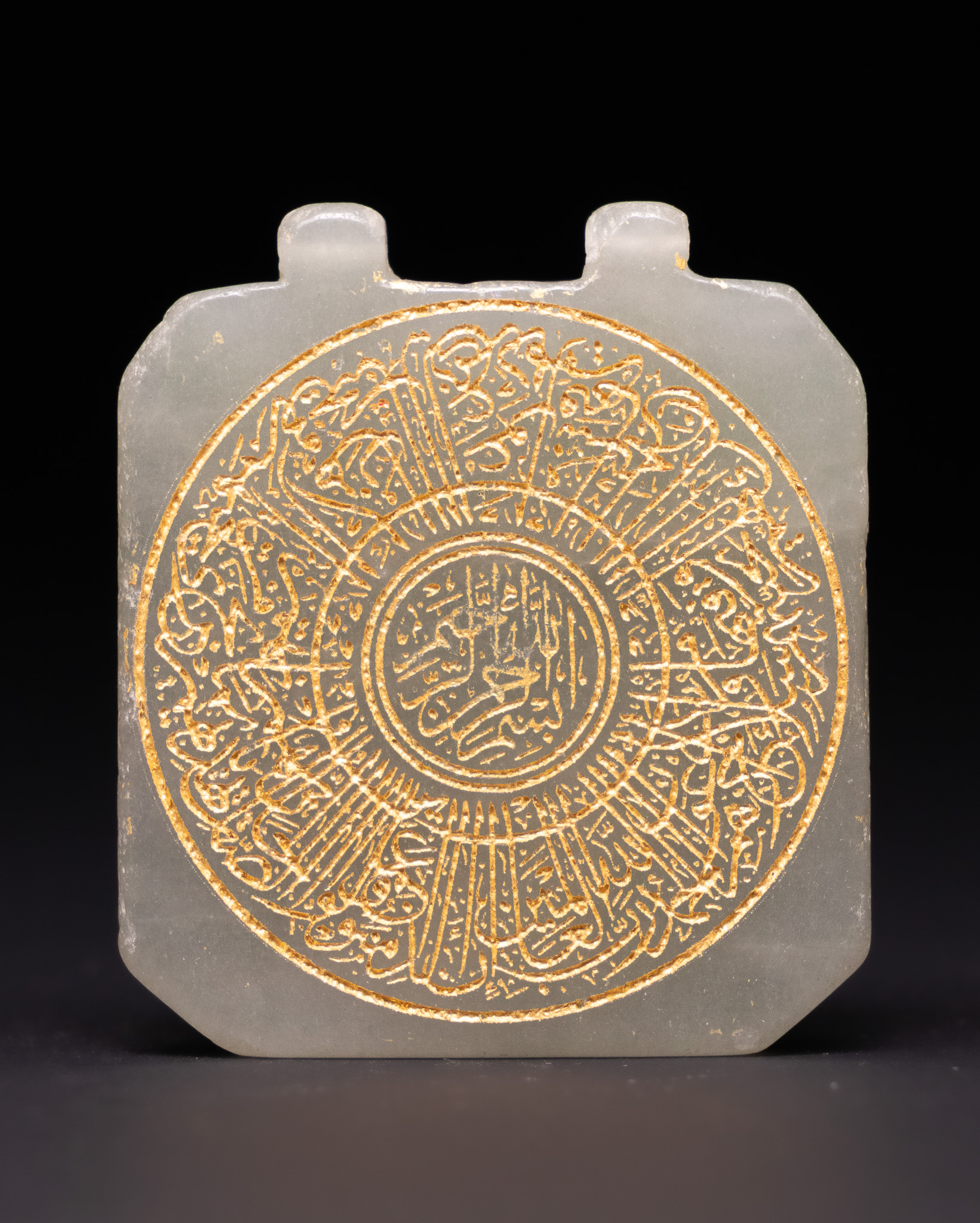 A GILDED CELADON NEPHRITE JADE TALISMANIC PENDANT WITH ARABIC CALLIGRAPHY.