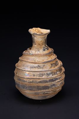 A ROMAN BLOWN GLASS BOTTLE WITH APPLIED TRAILING, CIRCA 7TH CENTURY. An ancient glass vessel 