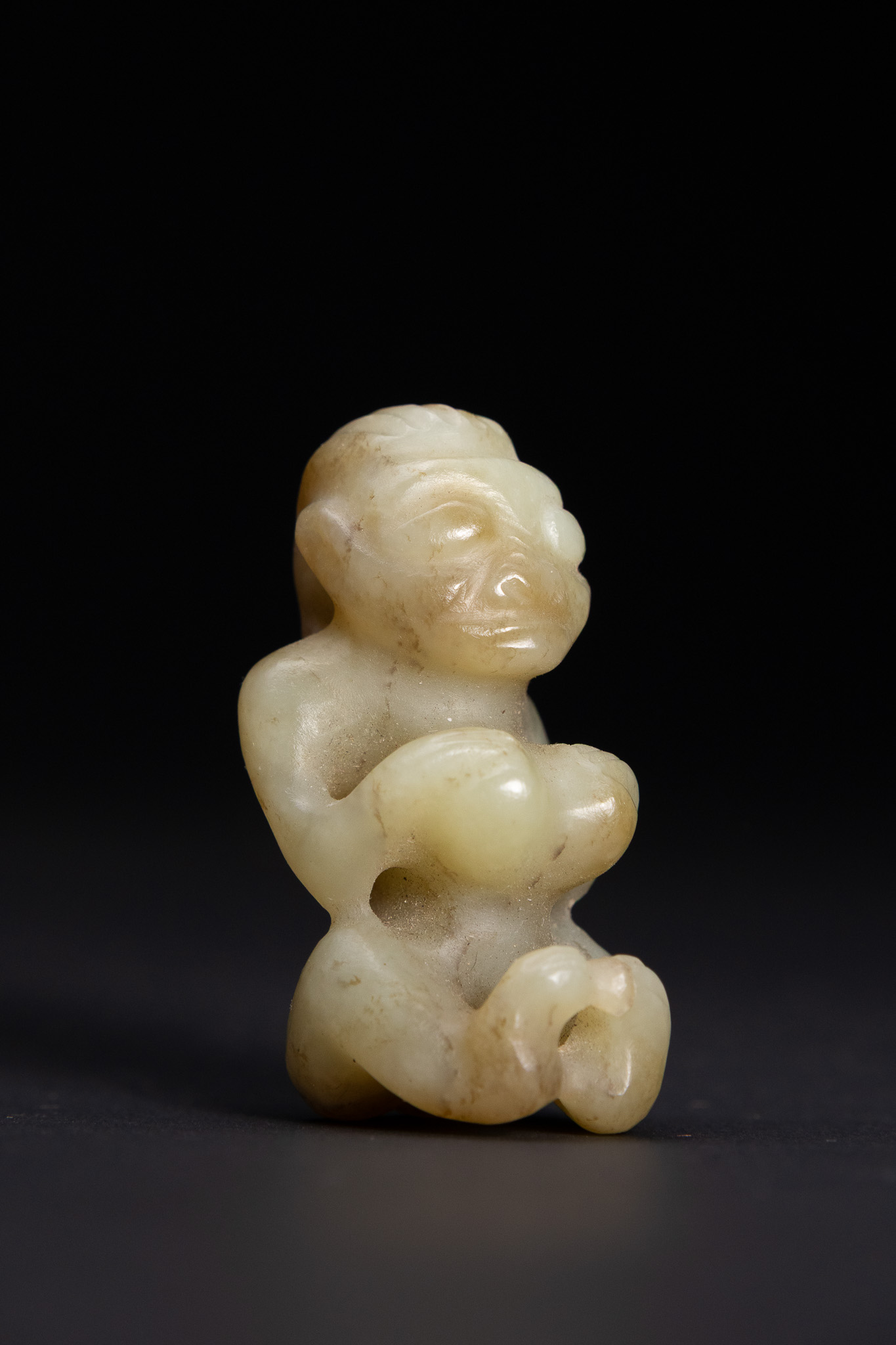 A CHINESE ARCHAIC STYLE CARVED PALE GREEN JADE SUN GOD FIGURINE.
