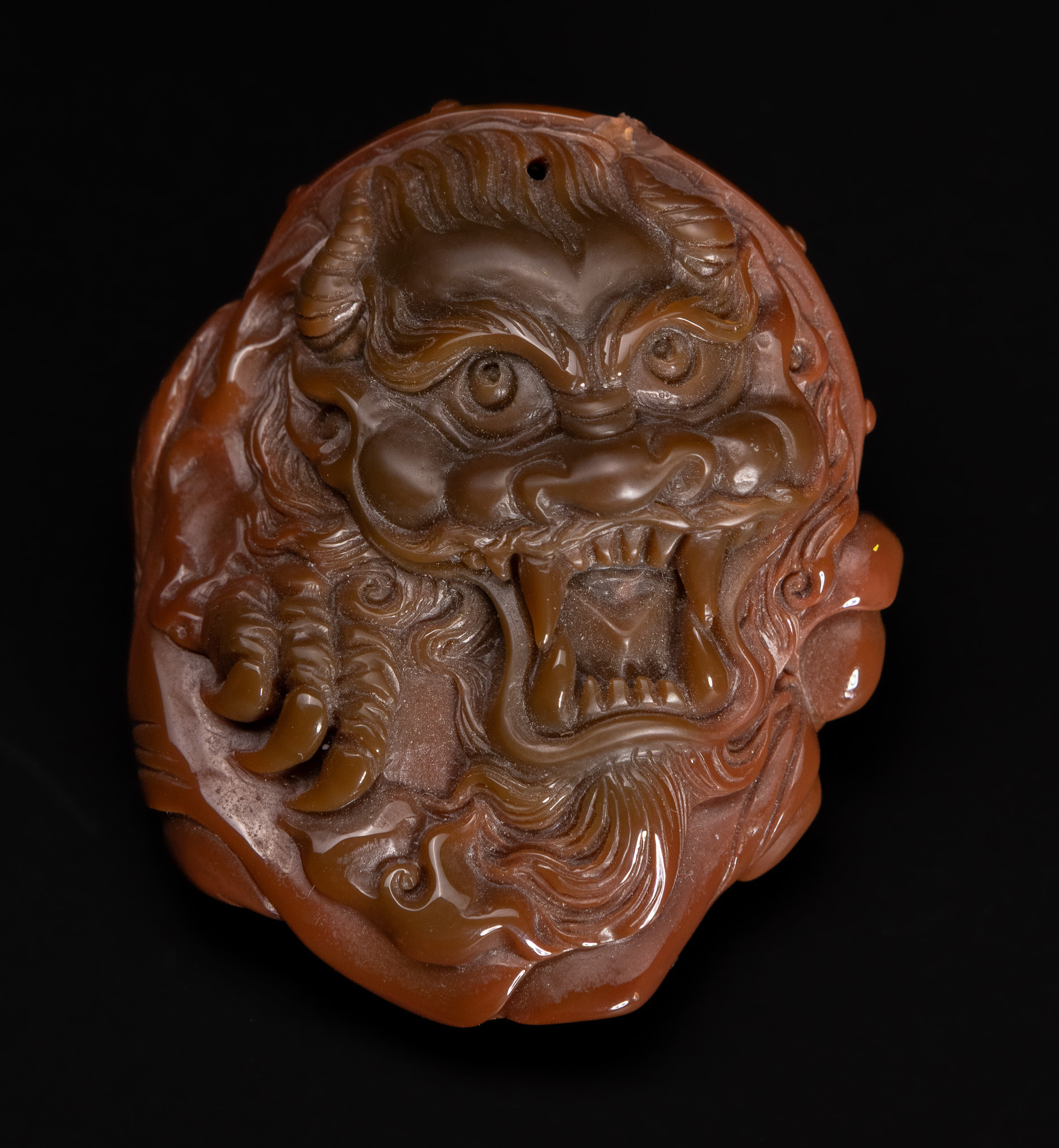 A CHINESE CARVED AGATE MYTHICAL BEAST AND ELEPHANT PENDANT.