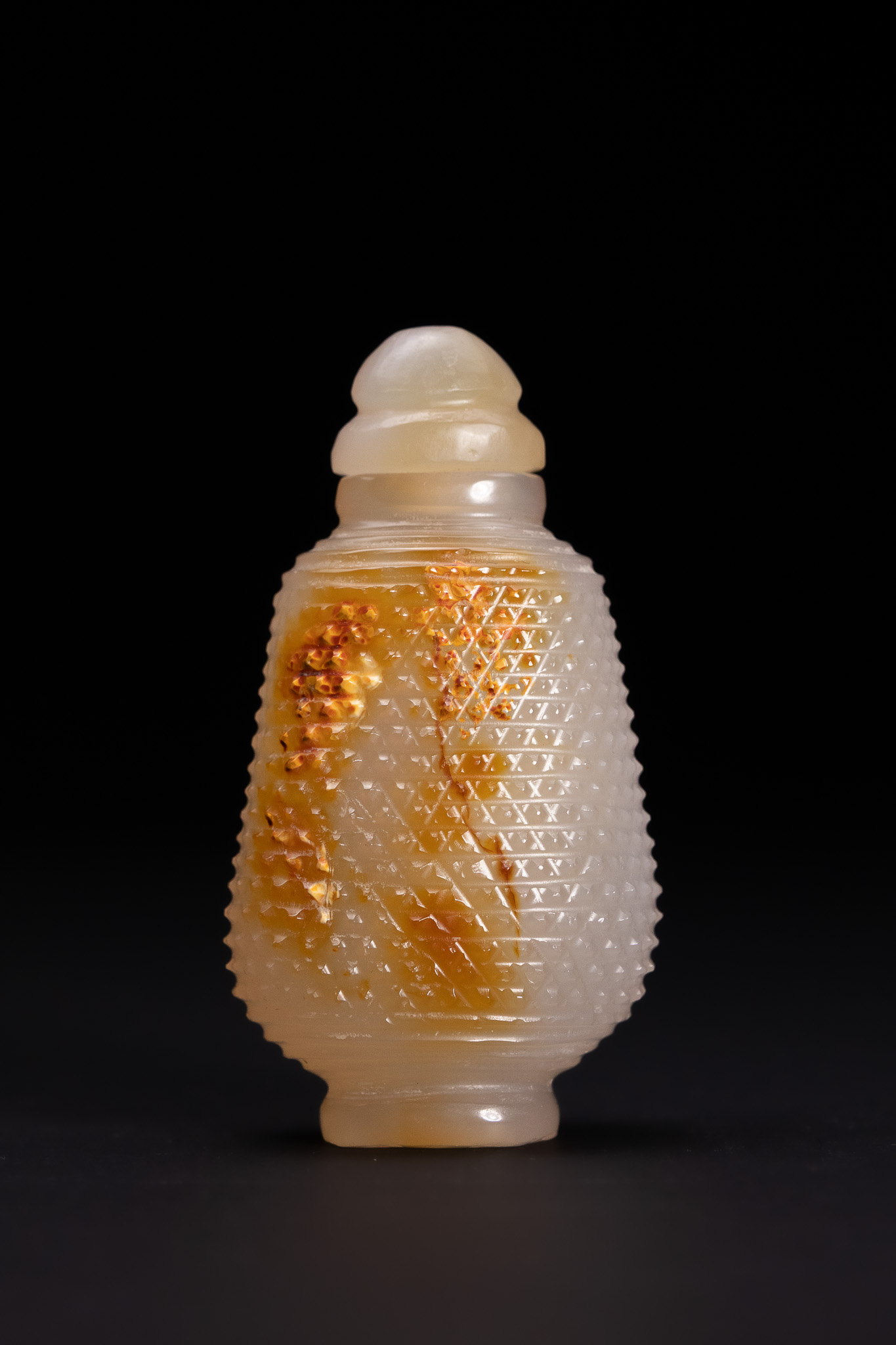 A CHINESE CARVED AGATE SNUFF BOTTLE WITH RUSSET INCLUSIONS.