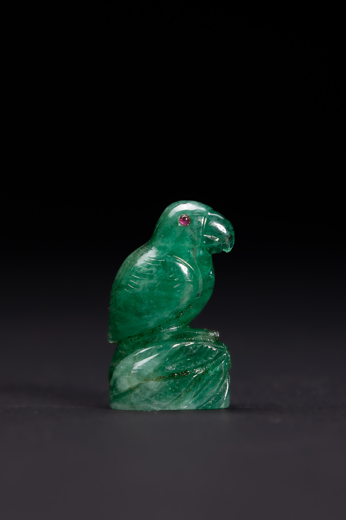 A CARVED EMERALD AND RUBY FIGURE OF A PARROT IN THE MUGHAL STYLE.