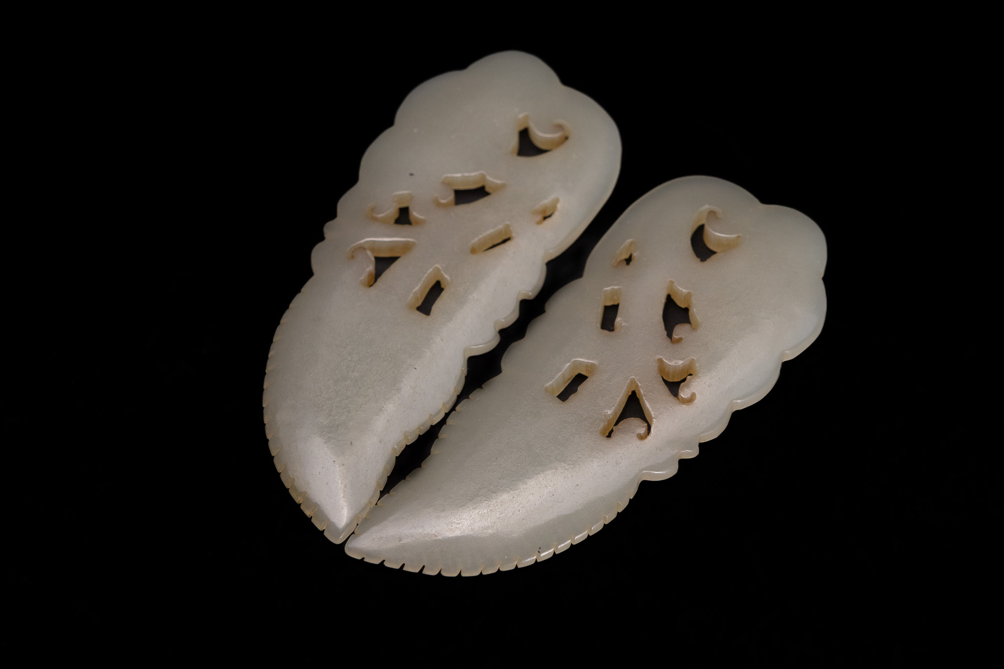A PAIR OF CHINESE CARVED WHITE JADE LEAF AND SHOU CHARACTER ORNAMENTS.