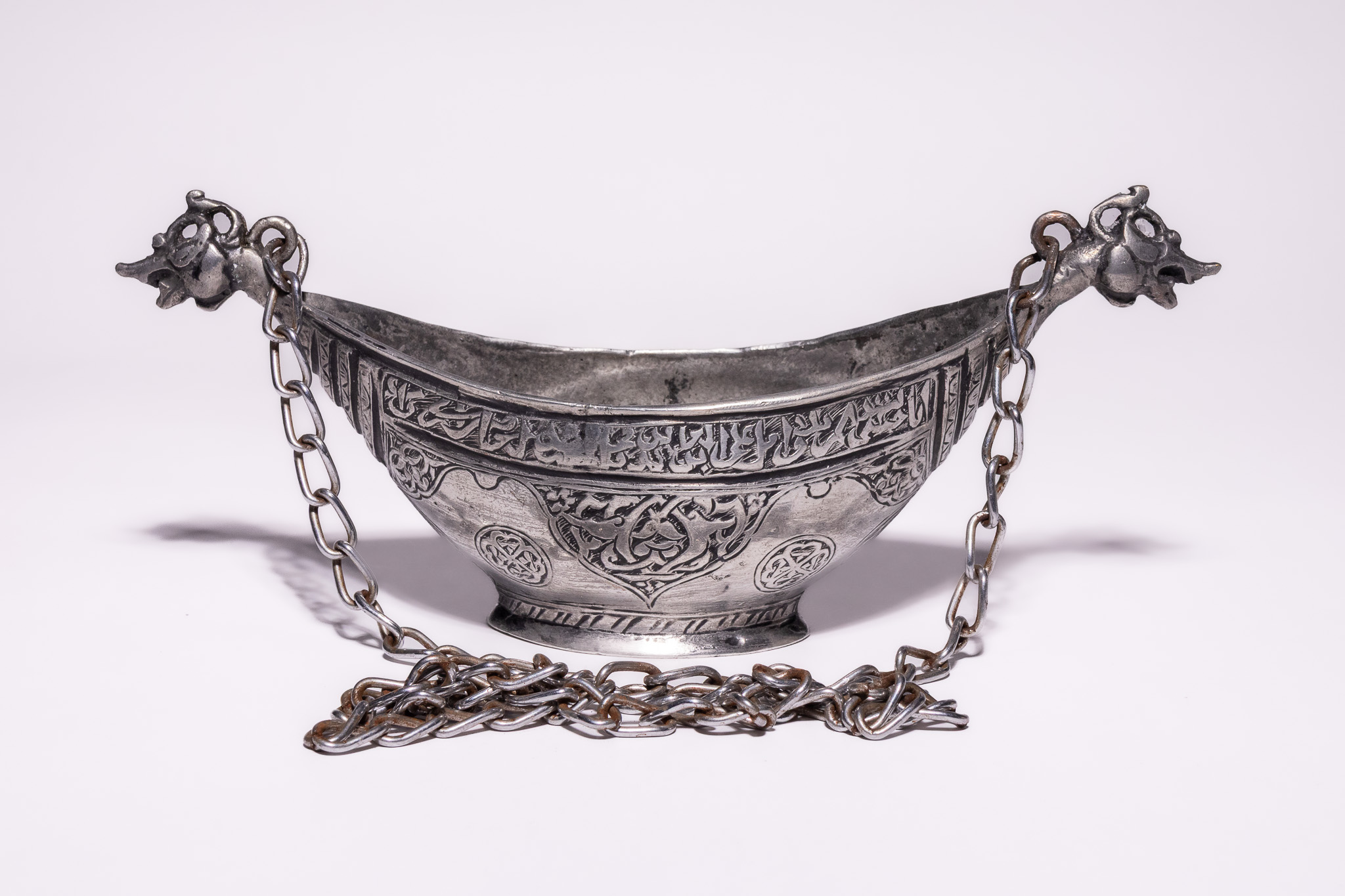A PERSIAN QAJAR TINNED COPPER KASHKUL BEGGAR'S BOWL, 19TH-20TH CENTURY.