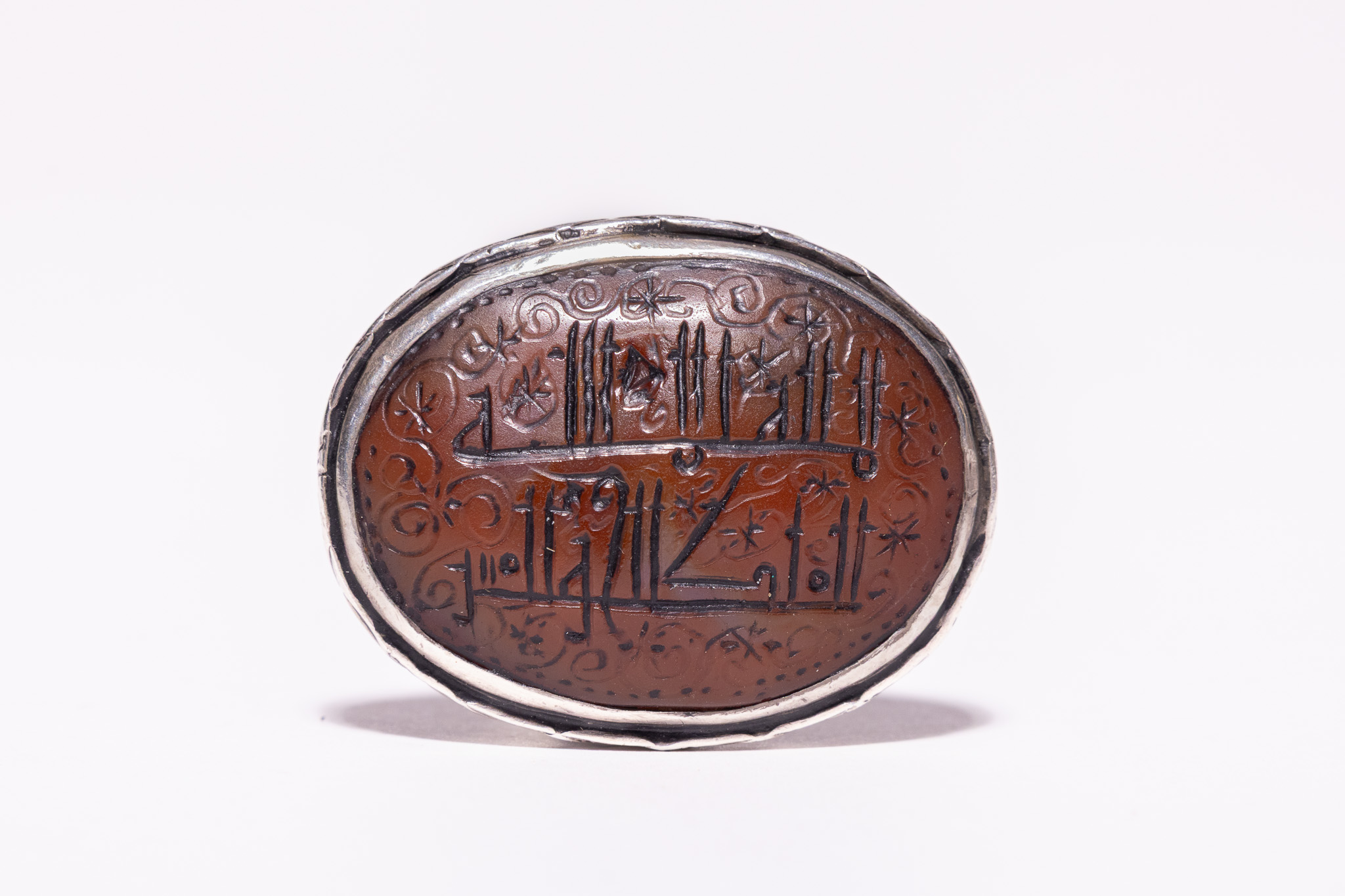 AN ISLAMIC SILVER AND CARNELIAN TALISMANIC SIGNET RING.