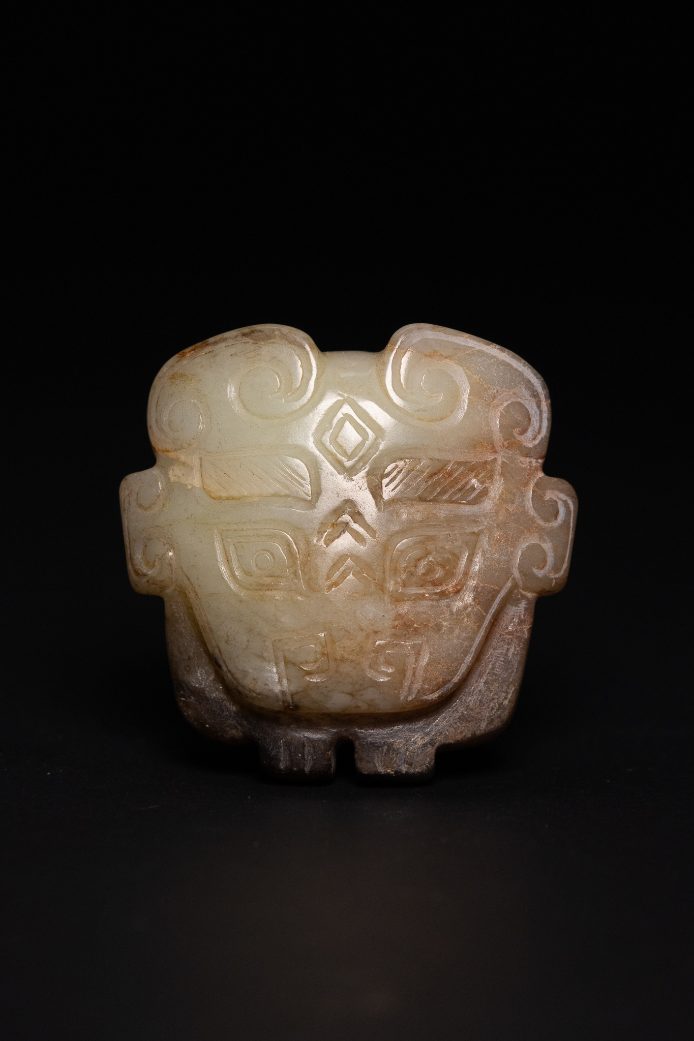 AN ARCHAISTIC CHINESE NEPHRITE JADE ANIMAL MASK PENDANT.