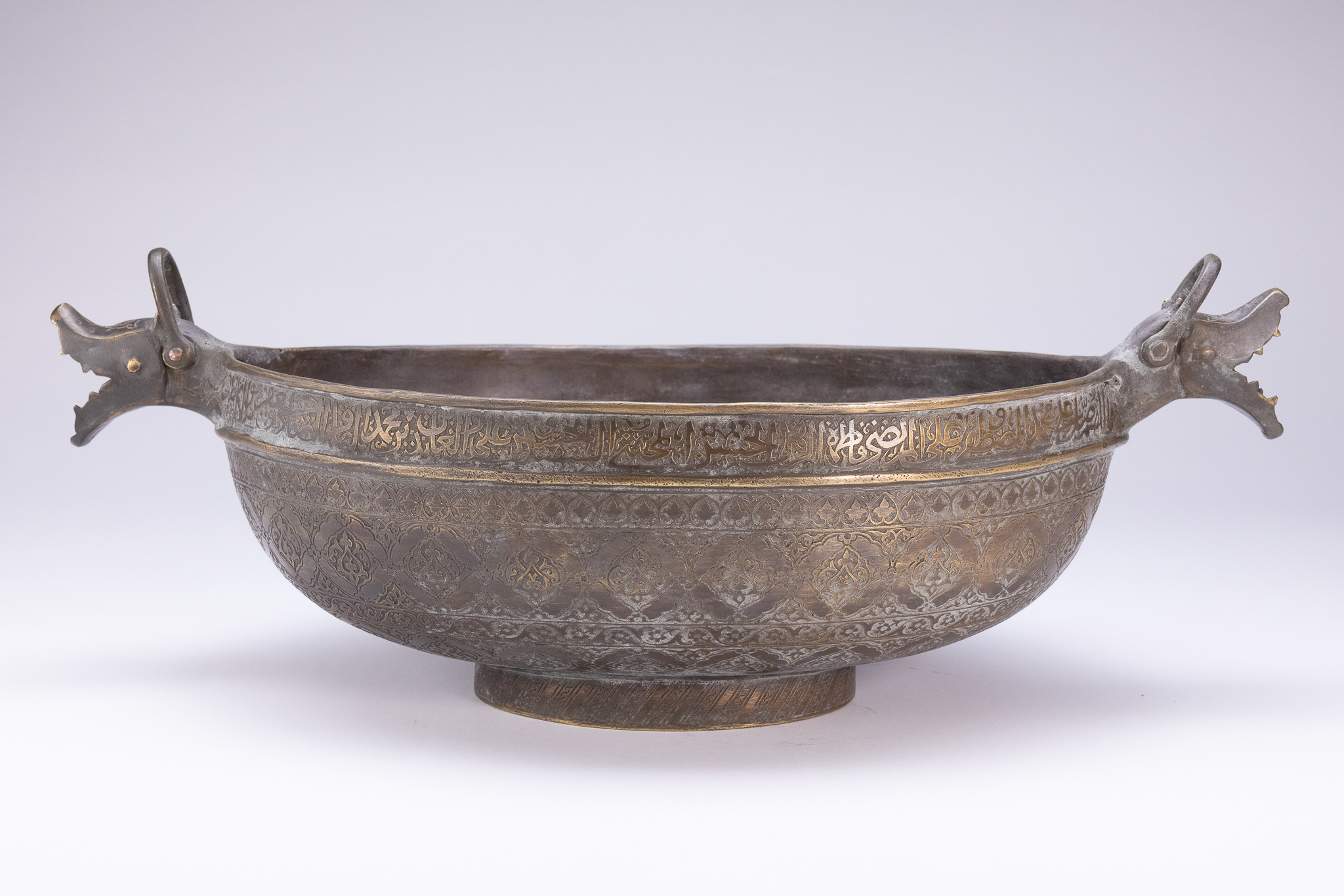 A SAFAVID STYLE BRASS KASHKUL (BEGGAR'S BOWL) WITH DRAGON HANDLES.