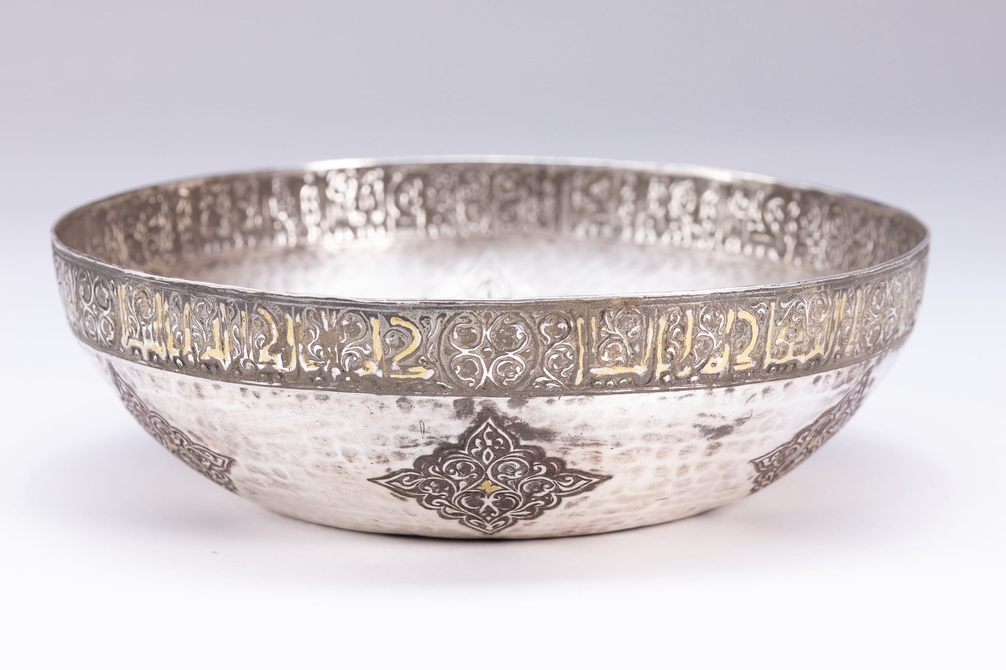 A PERSIAN QAJAR STYLE HAMMERED SILVERED AND PARCEL-GILT FISH POND BOWL