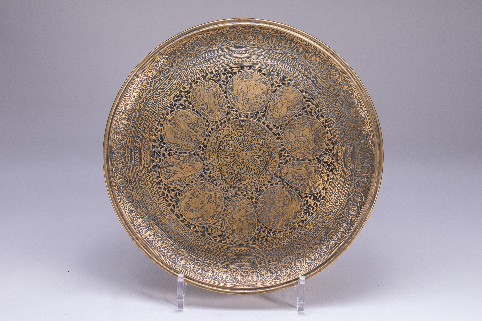 A PERSIAN ENGRAVED AND CHASED BRASS PLATE.