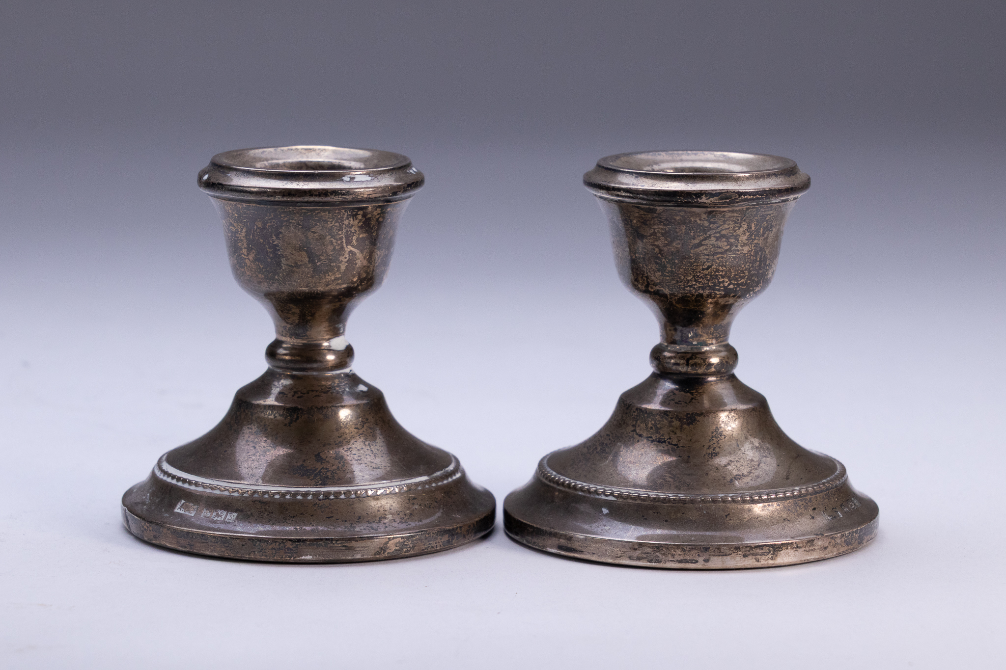 A PAIR OF GEORGE V STERLING SILVER WEIGHTED CANDLESTICKS, ALBERT EDWARD CHAPPLE, BIRMINGHAM, 1916-1917.