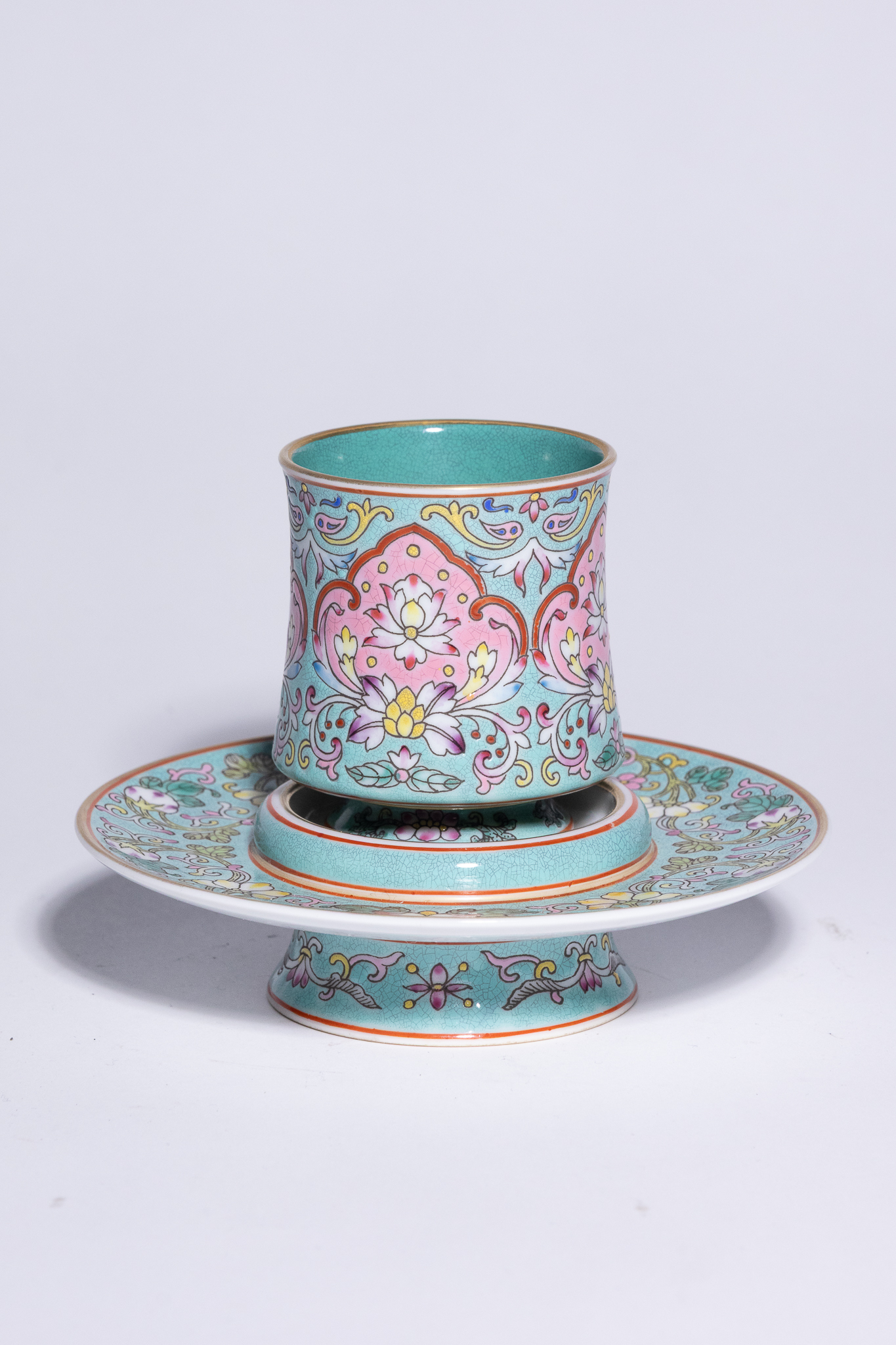 A CHINESE FAMILLE ROSE TURQUOISE-GROUND GRAVIATA PORCELAIN CUP AND STAND.