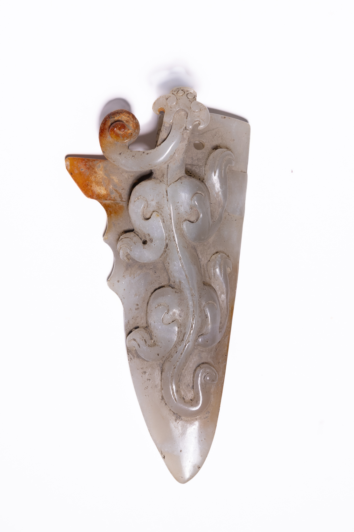 A CHINESE CARVED CELADON AND RUSSET JADE ARCHAISTIC CHILONG RITUAL BLADE PENDANT.