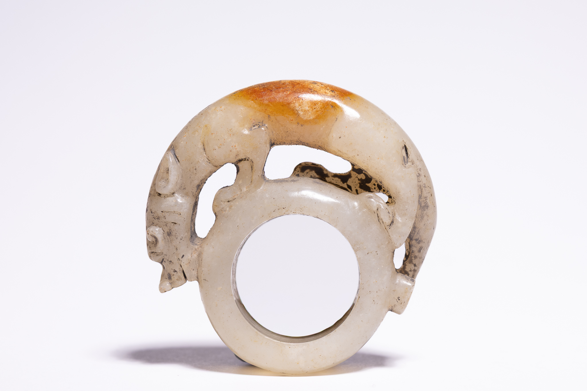 A CHINESE ARCHAISTIC CARVED CELADON AND RUSSET JADE BIXIE RING PENDANT.