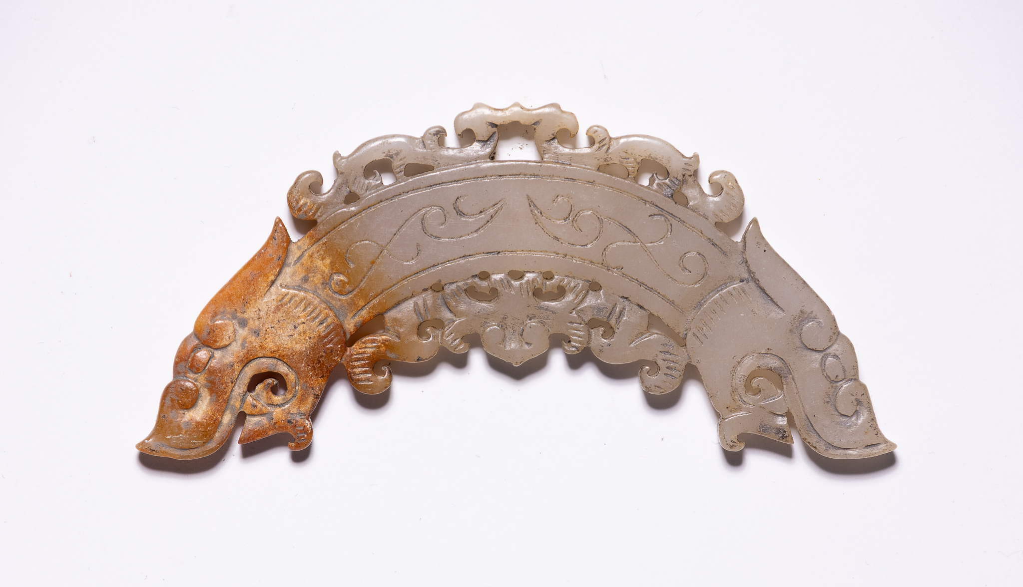 A CHINESE CARVED JADE DOUBLE-DRAGON RITUAL HUANG PENDANT.