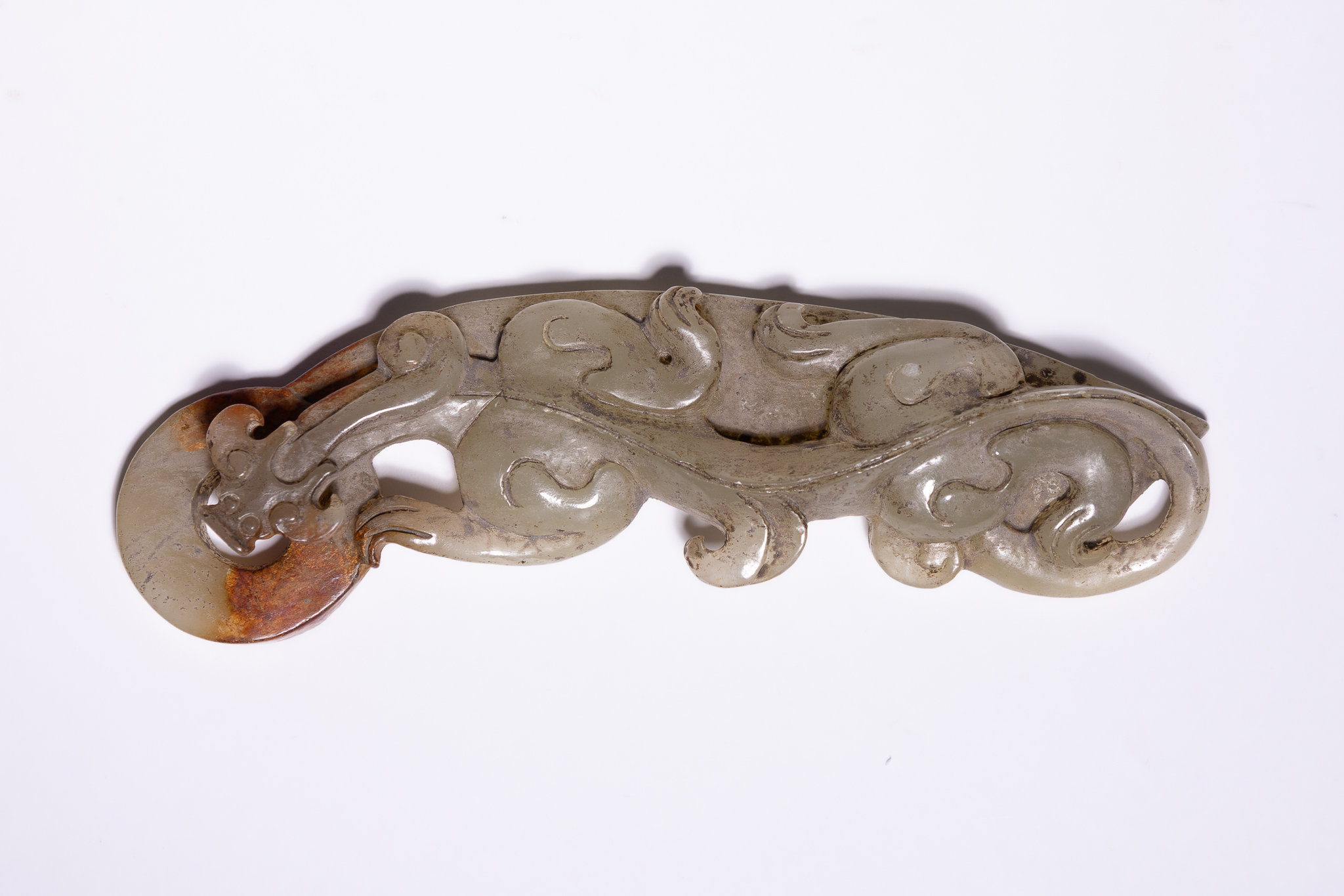 A CHINESE CARVED PALE CELADON AND RUSSET JADE CHILONG PLAQUE.