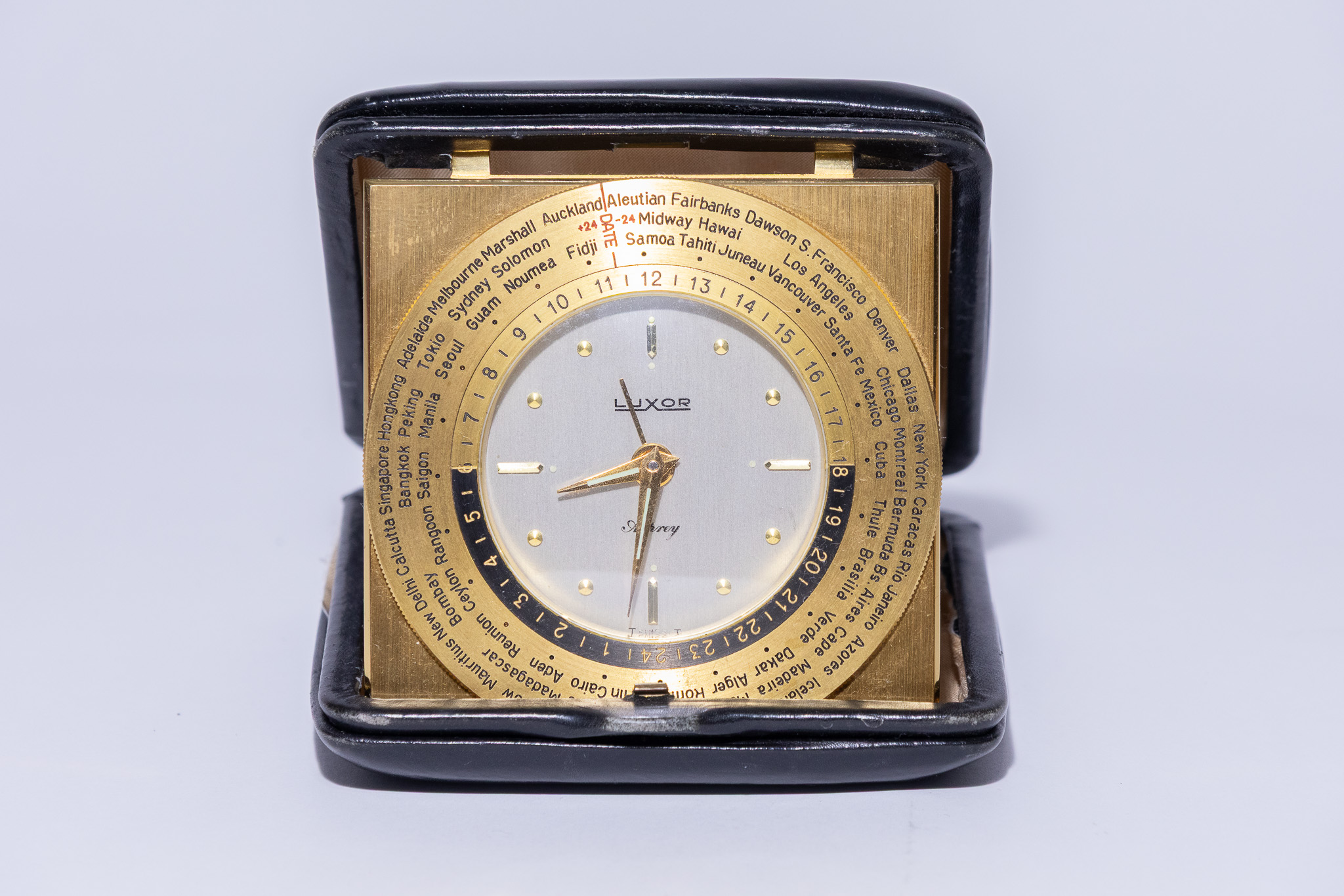 A VINTAGE LUXOR GILT BRASS AND LEATHER WORLD TIME TRAVEL ALARM CLOCK RETAILED BY ASPREY, CIRCA 1980.