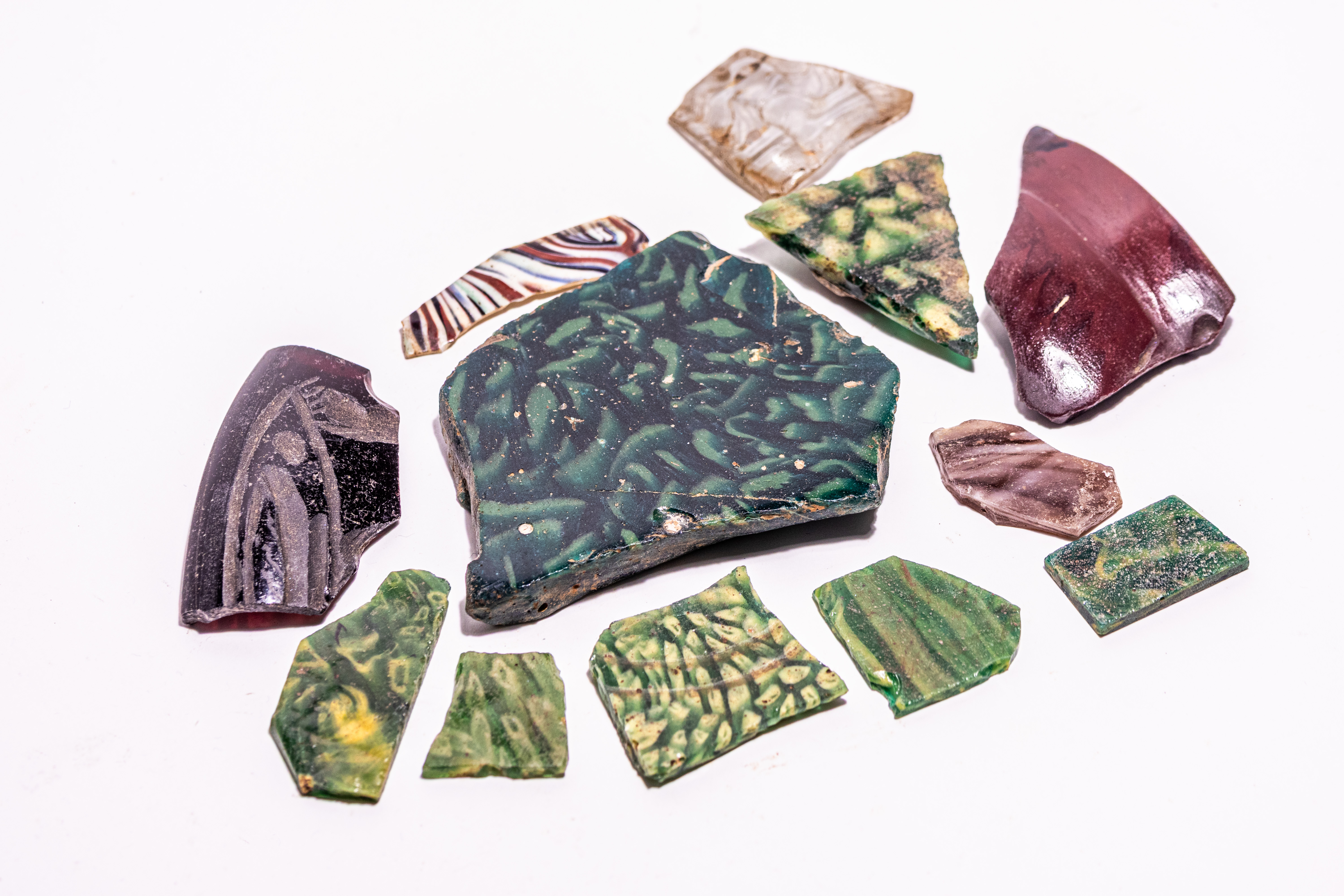 A COLLECTION OF TWELVE ANCIENT EGYPTIAN GLASS FRAGMENTS.