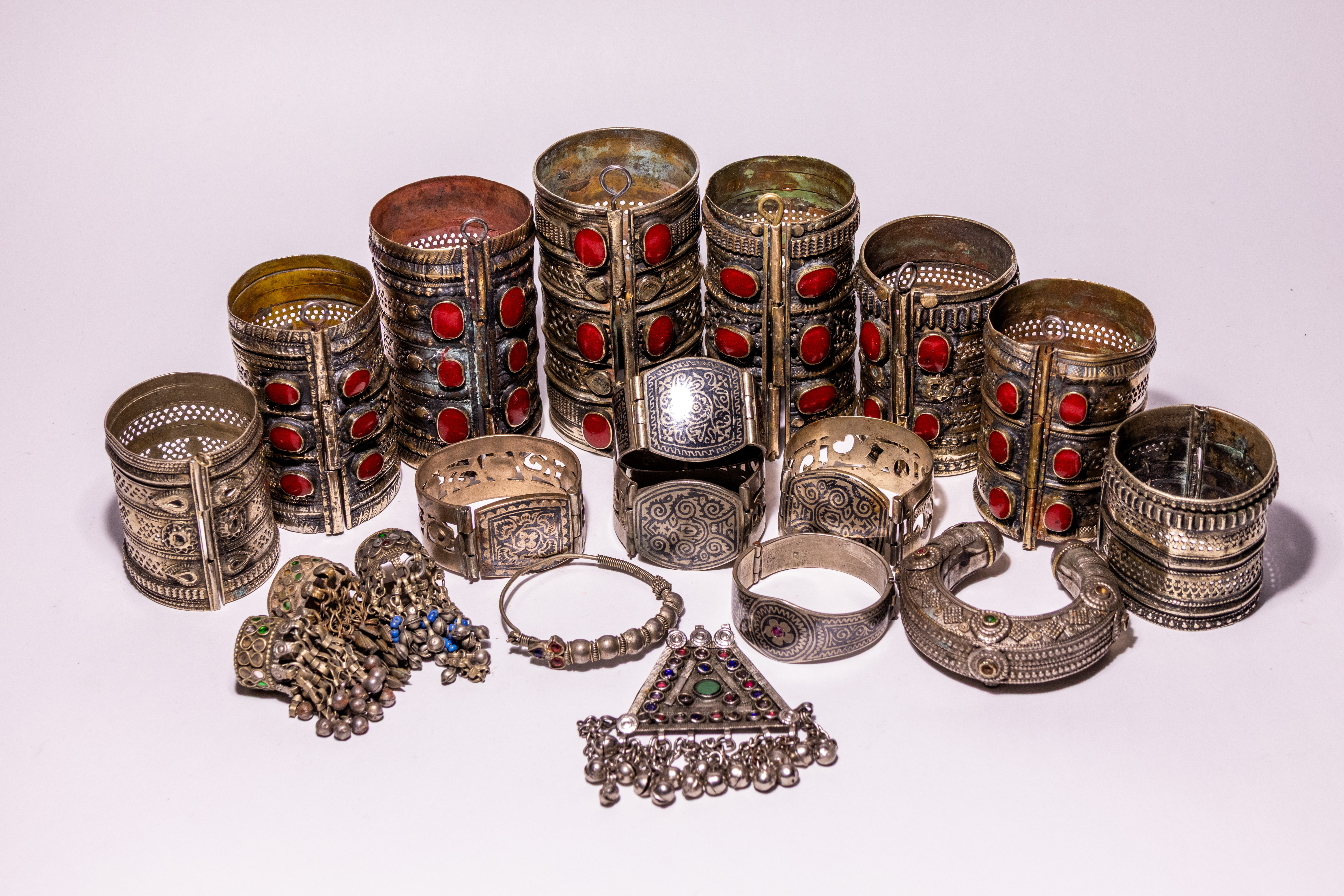 A COLLECTION OF MIDDLE EASTERN TRIBAL WHITE METAL AND GLASS SET JEWELLERY.
