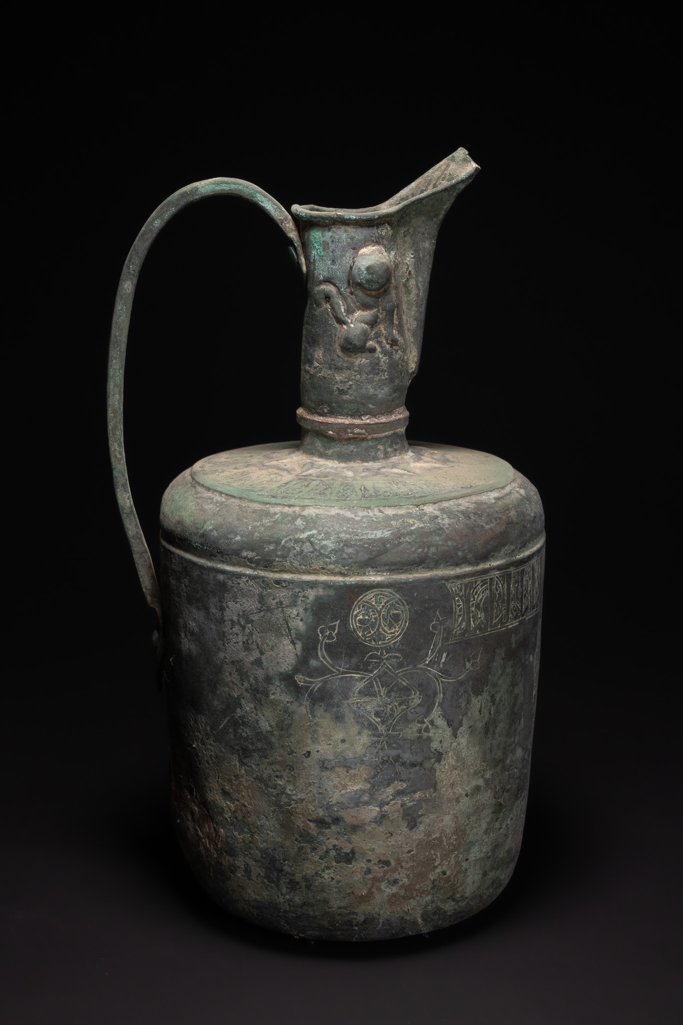 A SELJUK KHORASAN BRONZE EWER WITH CALLIGRAPHIC AND FIGURATIVE DECORATION, 11TH-12TH CENTURY.