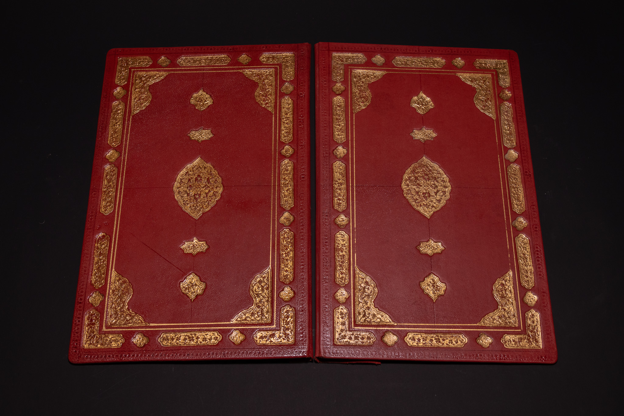 A PAIR OF GILT-STAMPED RED PERSIAN LEATHER QUR'AN COVERS WITH POLYCHROME FILIGREE DOUBLURES.
