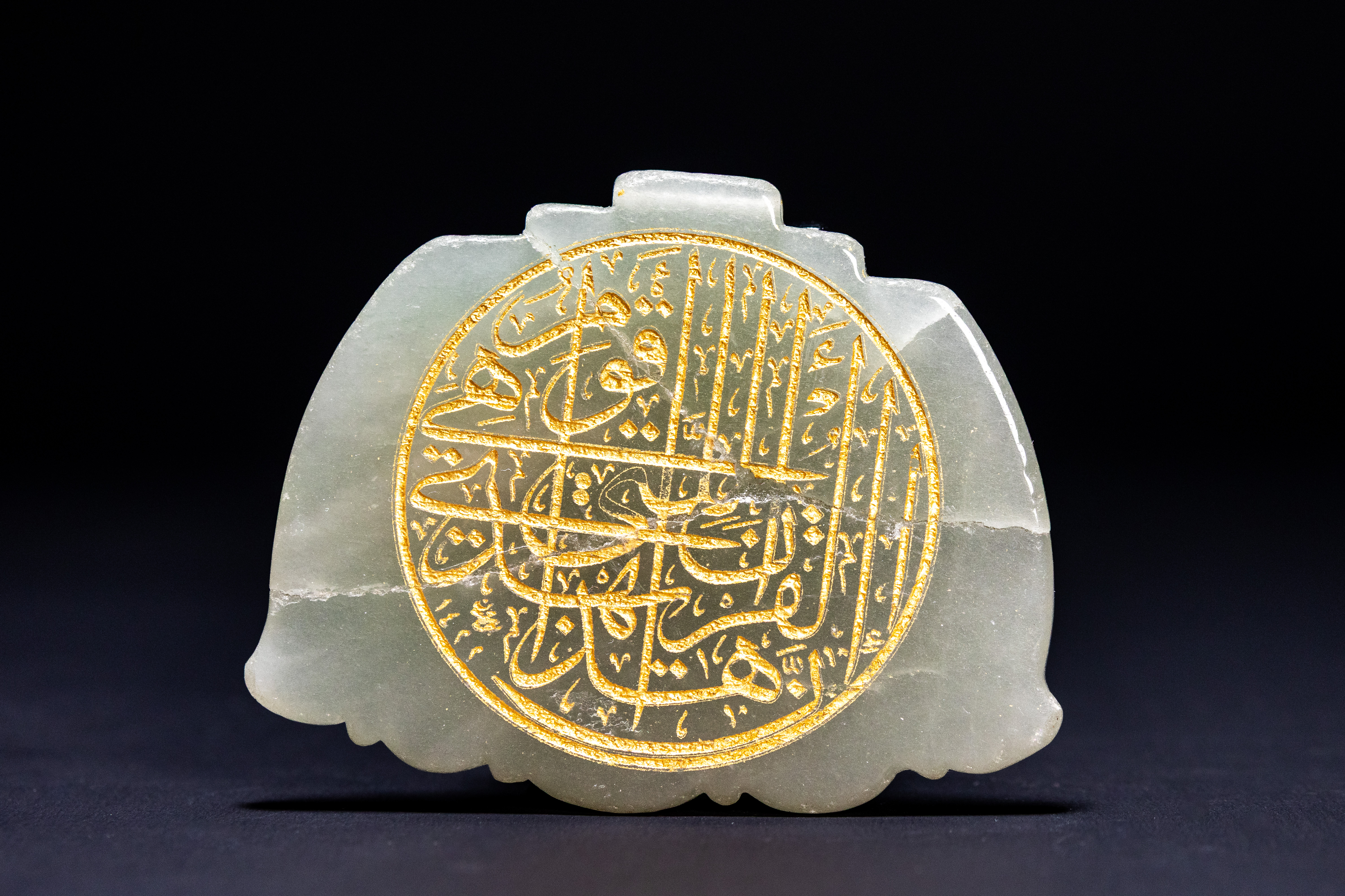 A SAFAVID STYLE PALE GREEN NEPHRITE JADE TALISMANIC PENDANT WITH GOLD-INLAID CALLIGRAPHY.