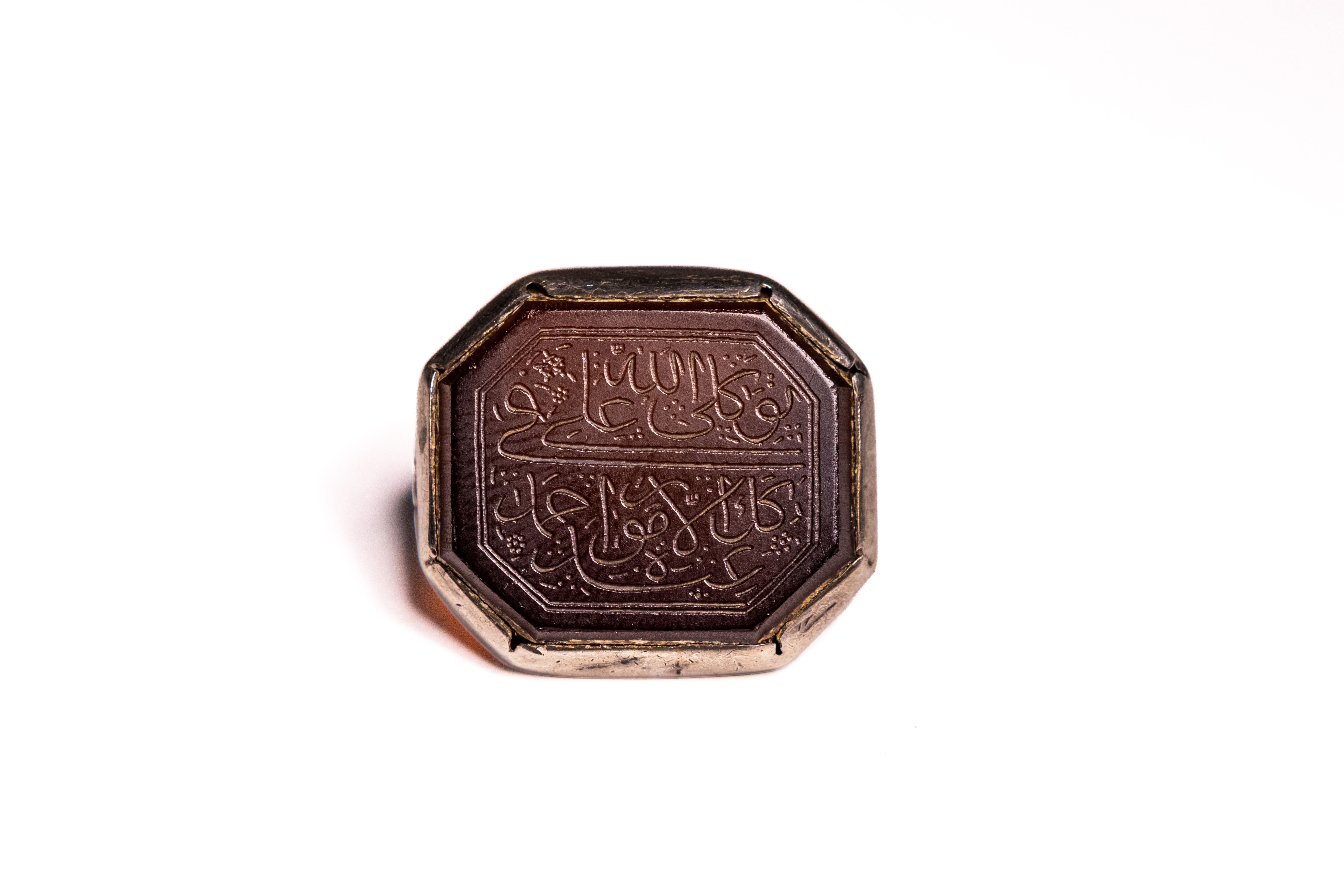AN ISLAMIC SILVER AND CARNELIAN CALLIGRAPHIC SIGNET RING.