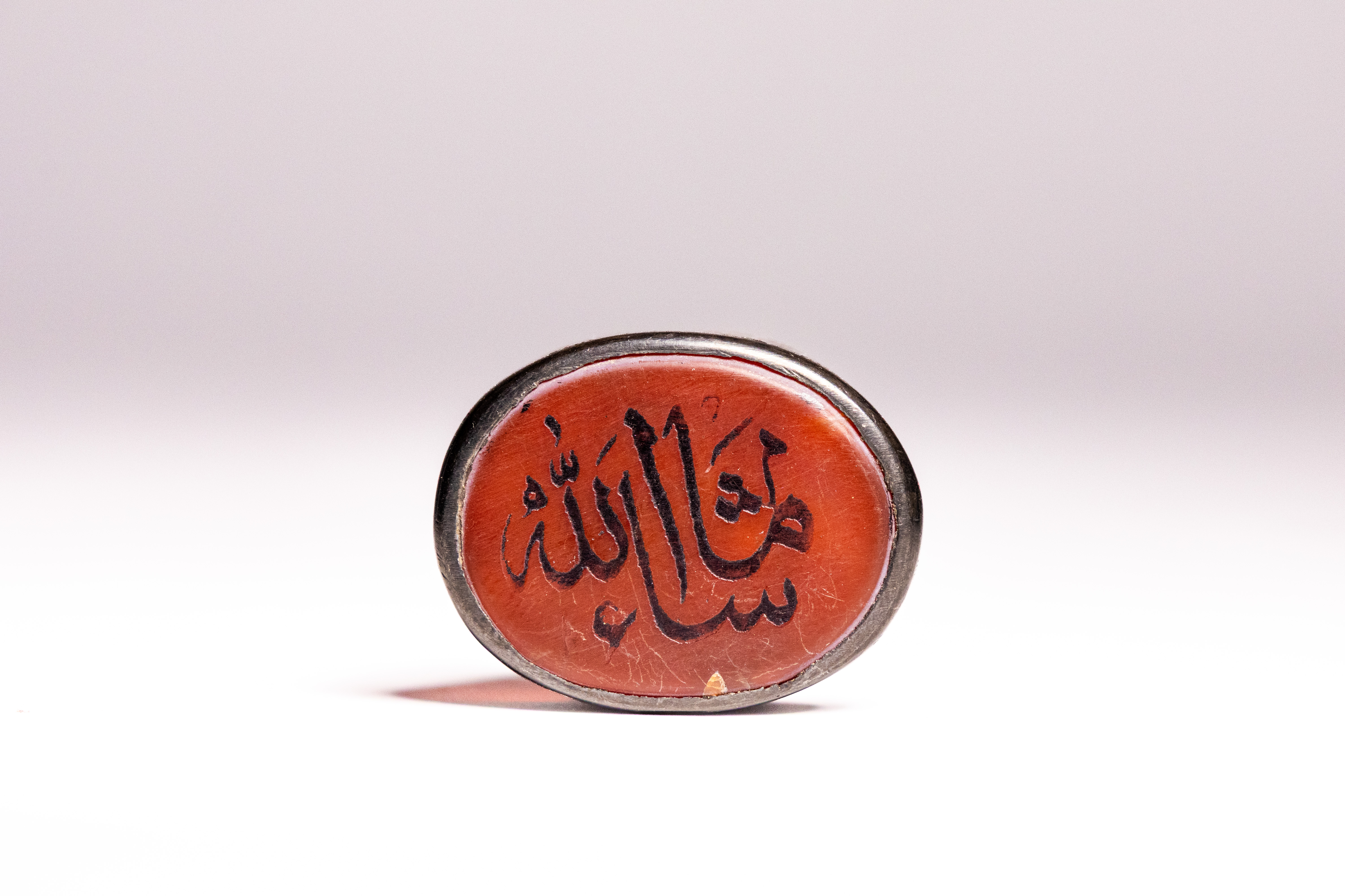 AN ISLAMIC SILVER AND ENGRAVED CARNELIAN SIGNET RING.