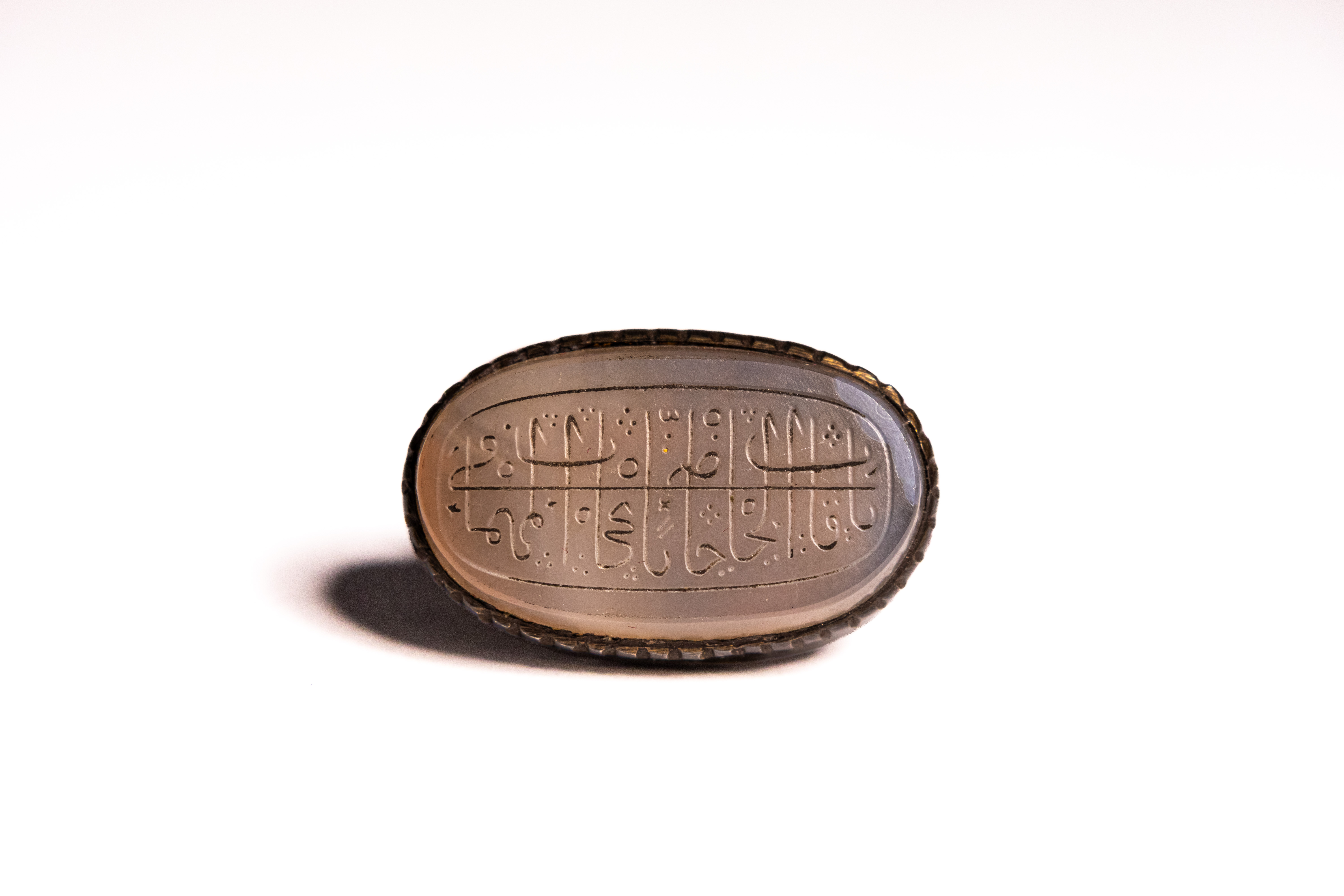 AN ISLAMIC INSCRIBED AGATE SIGNET RING.