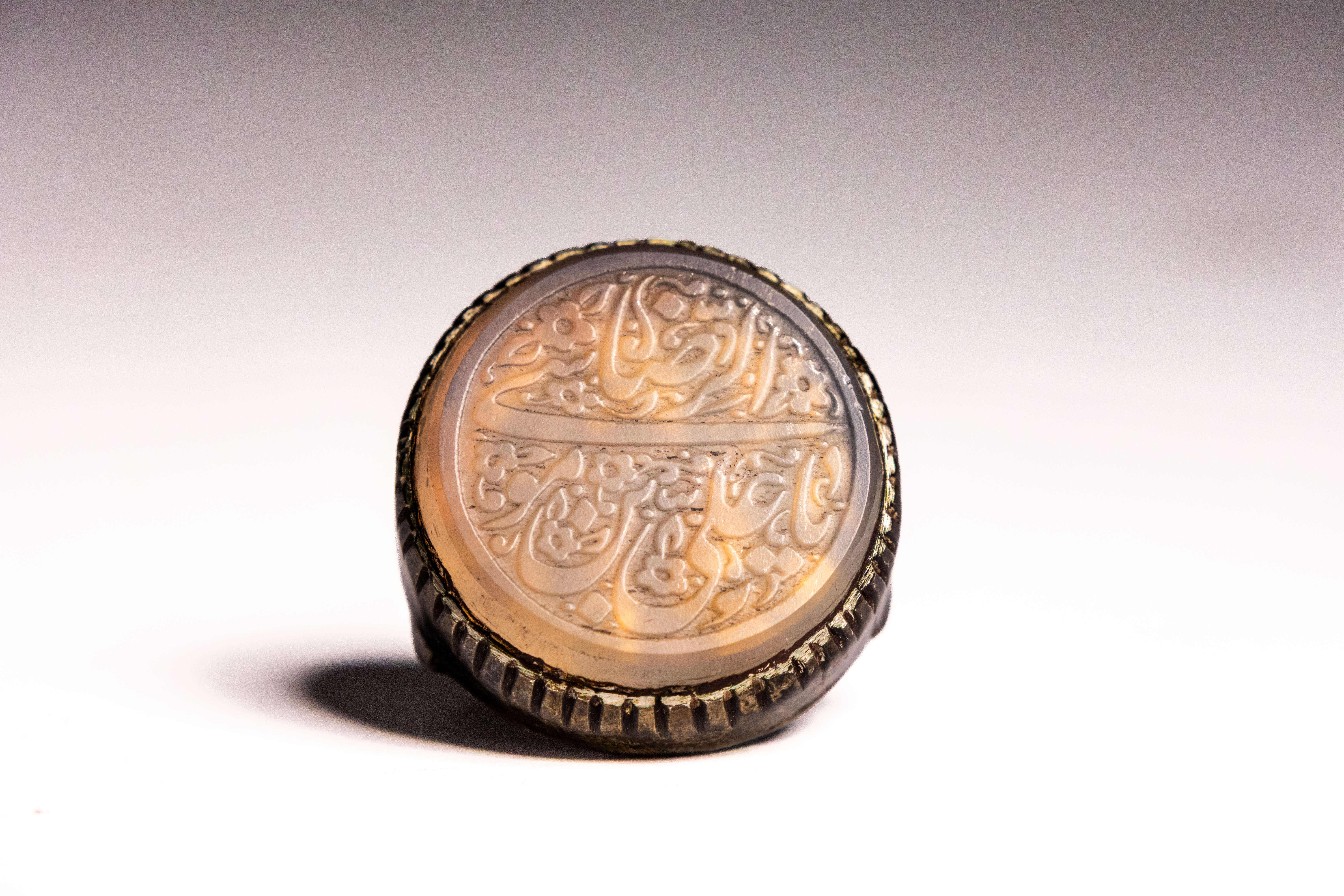 AN ISLAMIC SILVER AND AGATE INTAGLIO SEAL RING.