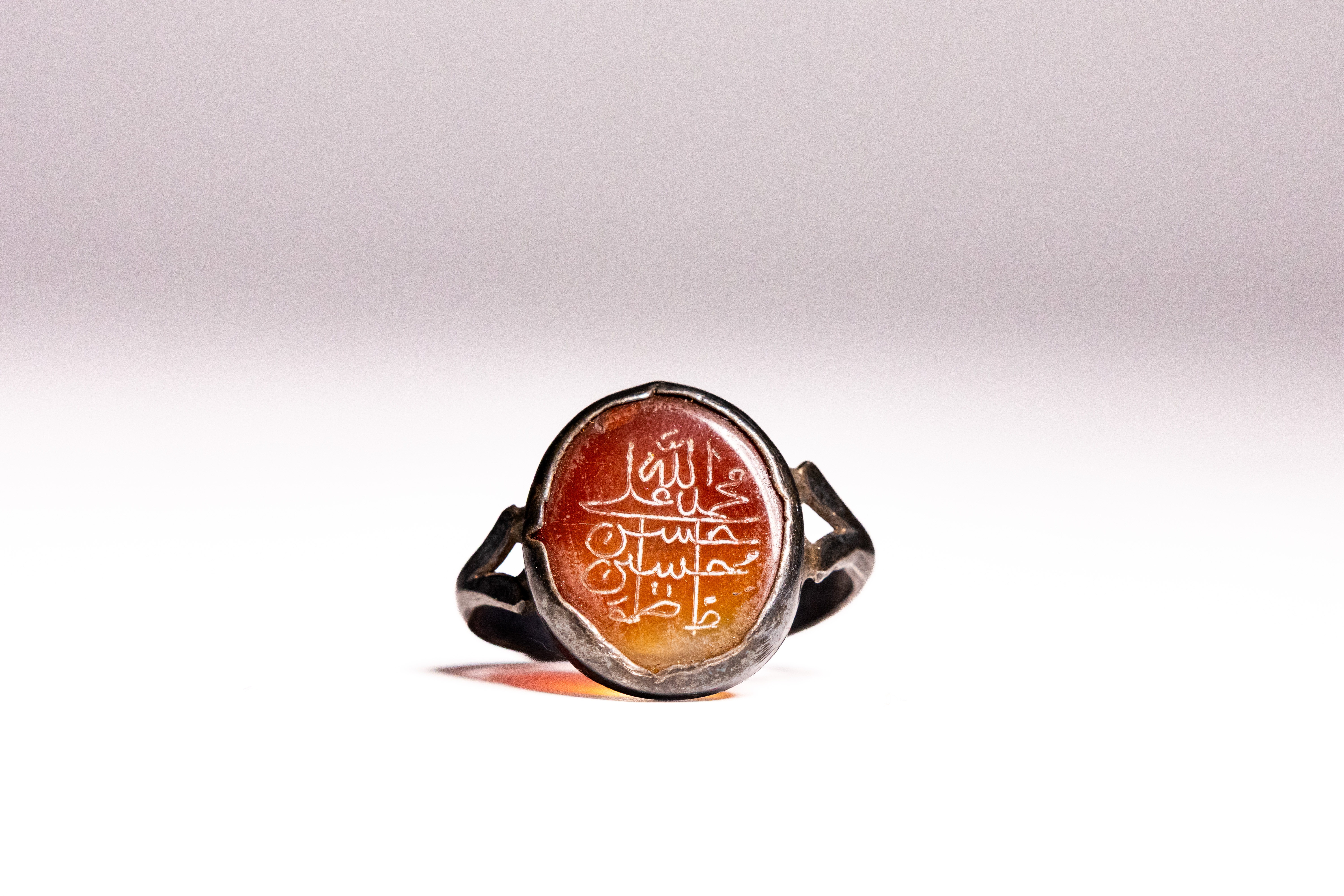 AN ISLAMIC SILVER AND CARNELIAN SWIVEL TALISMANIC RING.