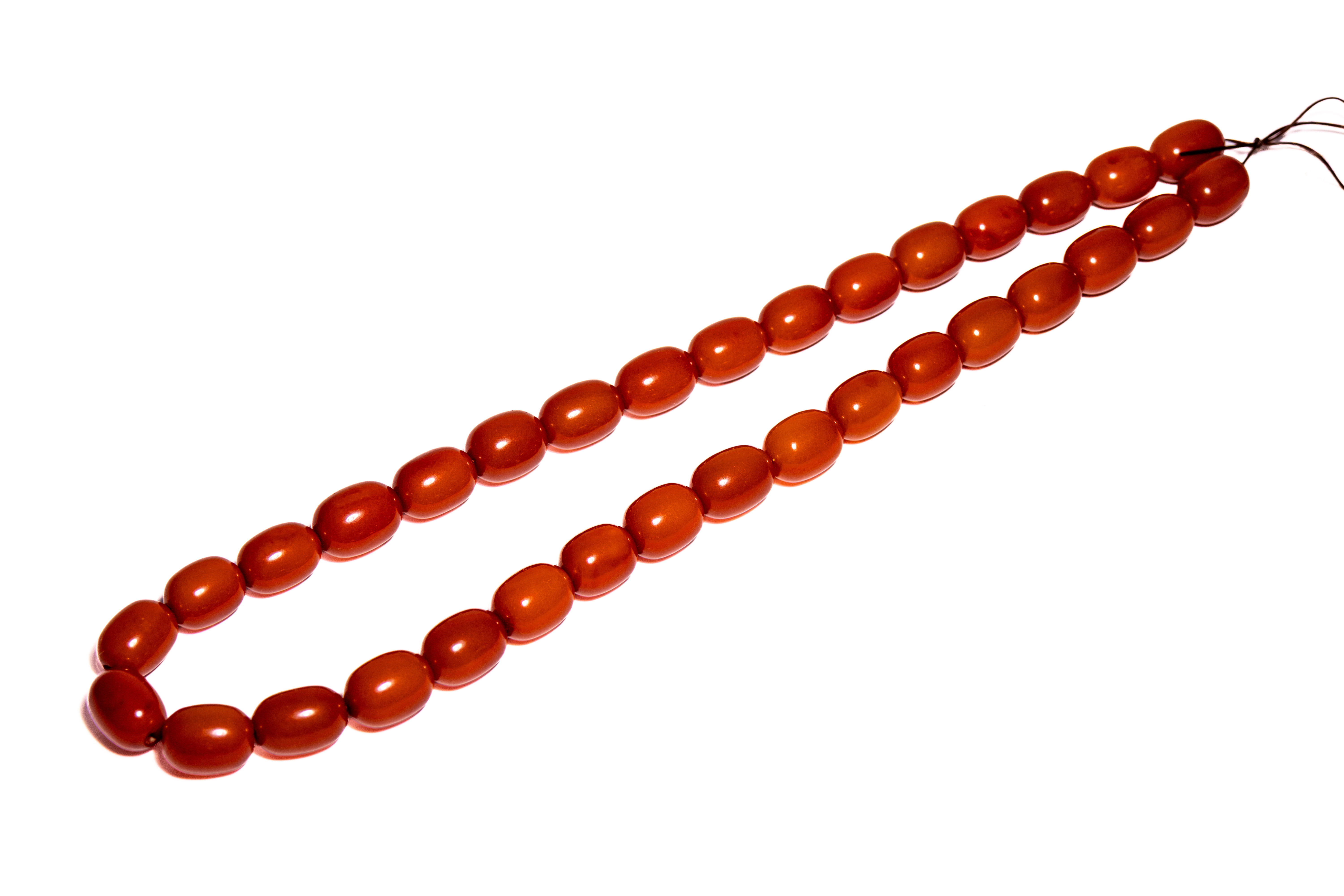 A STRAND OF THIRTY-THREE AMBER MISHABA BEADS.