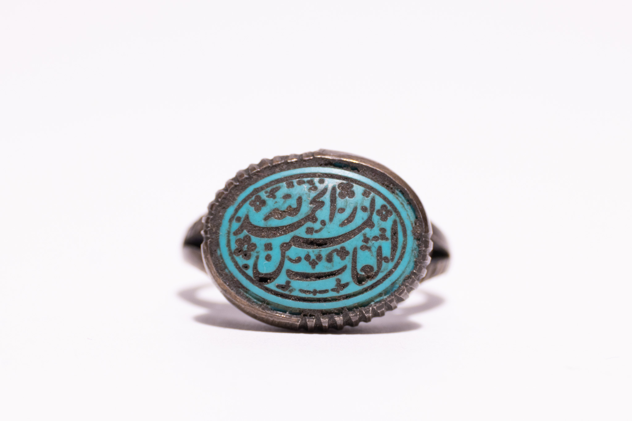 AN ISLAMIC INSCRIBED TURQUOISE AND SILVER SIGNET RING.