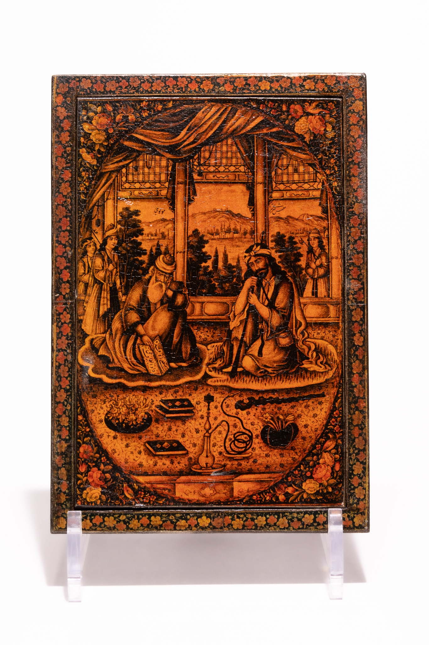 A QAJAR STYLE LACQUER MIRROR CASE WITH FIGURAL AND FLORAL DECORATION, POSSIBLY 19TH-20TH CENTURY.