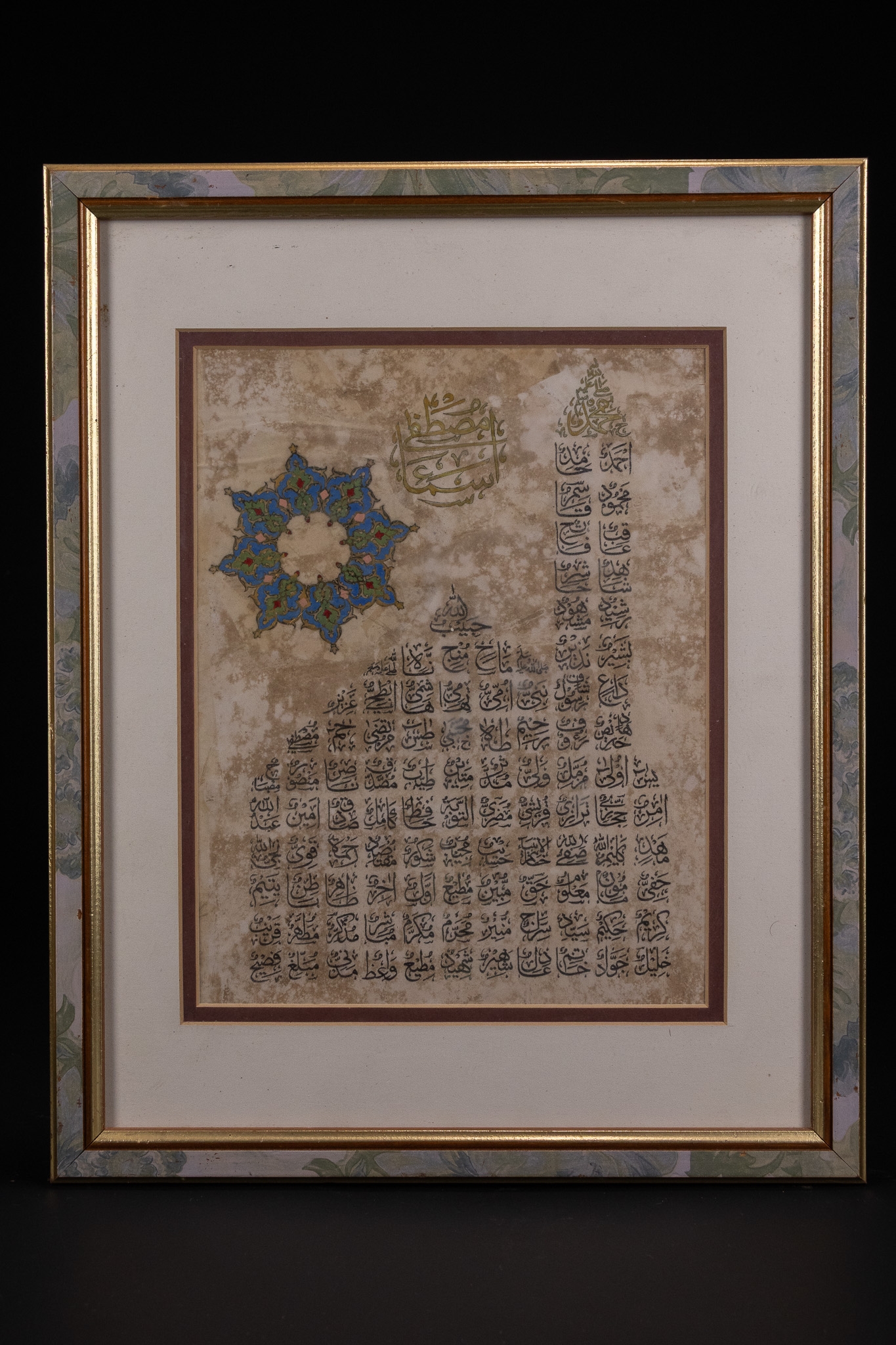 AN ISLAMIC CALLIGRAPHIC PANEL WITH ILLUMINATED ROSETTE, INK AND POLYCHROME ON PAPER.