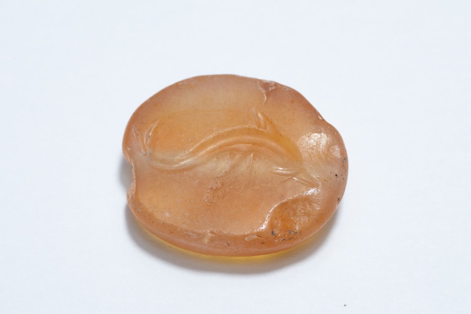 A GREEK CARNELIAN SCARAB GEM ENGRAVED WITH A DOLPHIN, POSSIBLY CIRCA 5TH–4TH CENTURY BC.