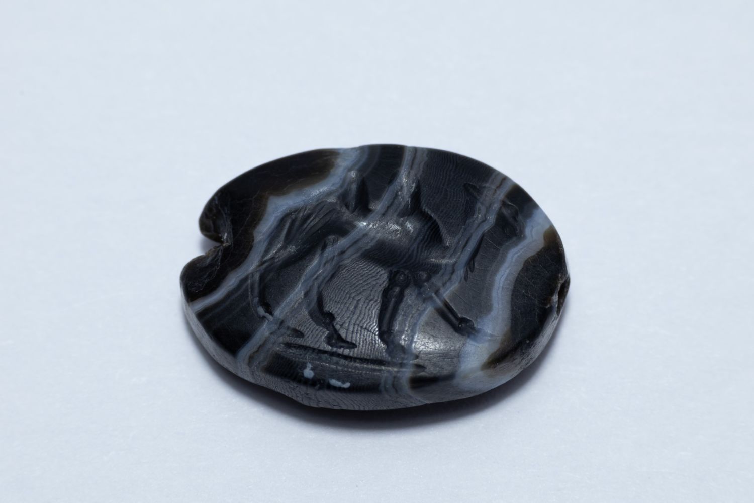 A FINE GREEK-PERSIAN BANDED AGATE SCARAB GEM ENGRAVED WITH A WALKING CAMEL, POSSIBLY CIRCA 5TH–4TH CENTURY BC.