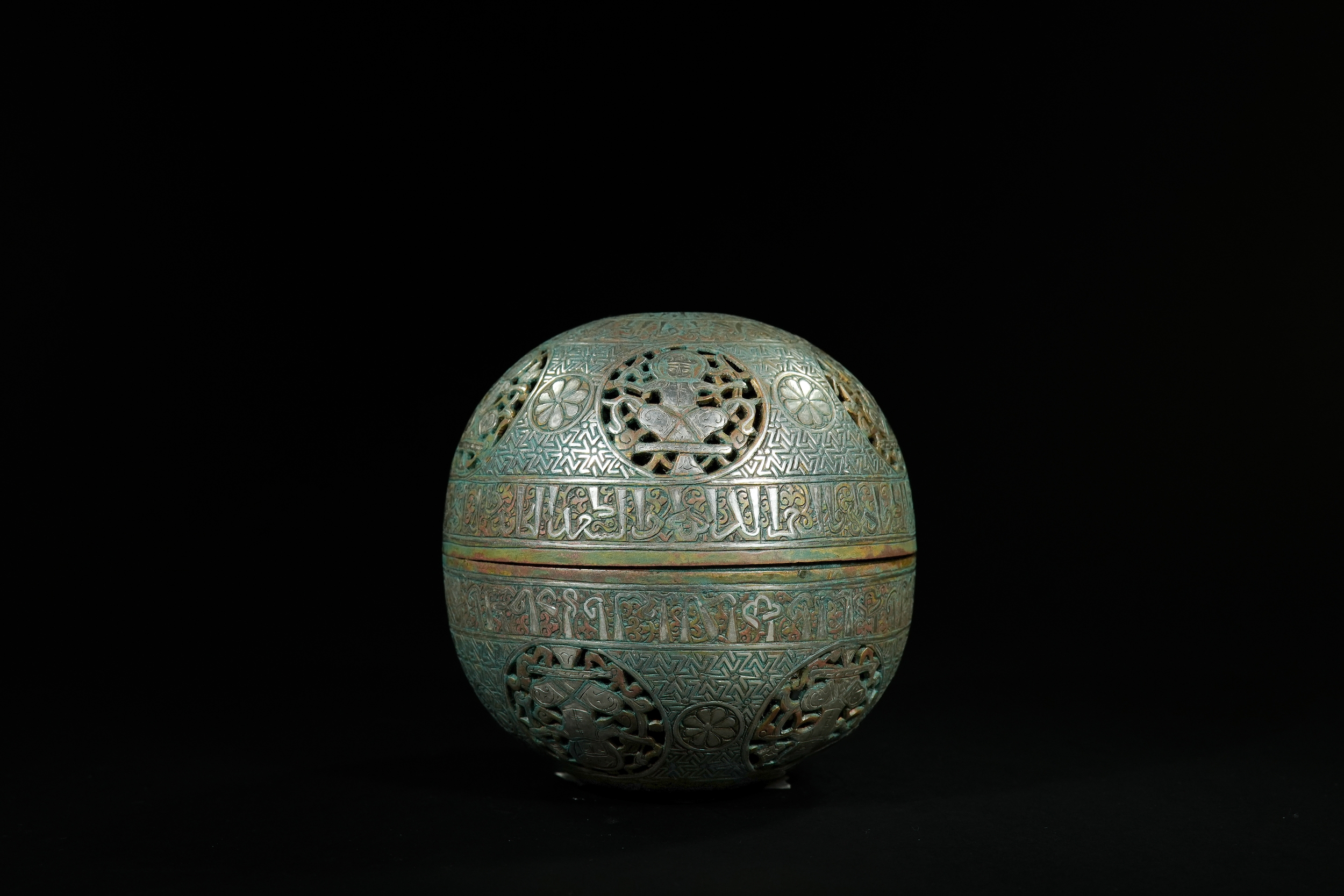 AN ISLAMIC BRASS SILVER-INLAID SPHERICAL LIDDED BOX.