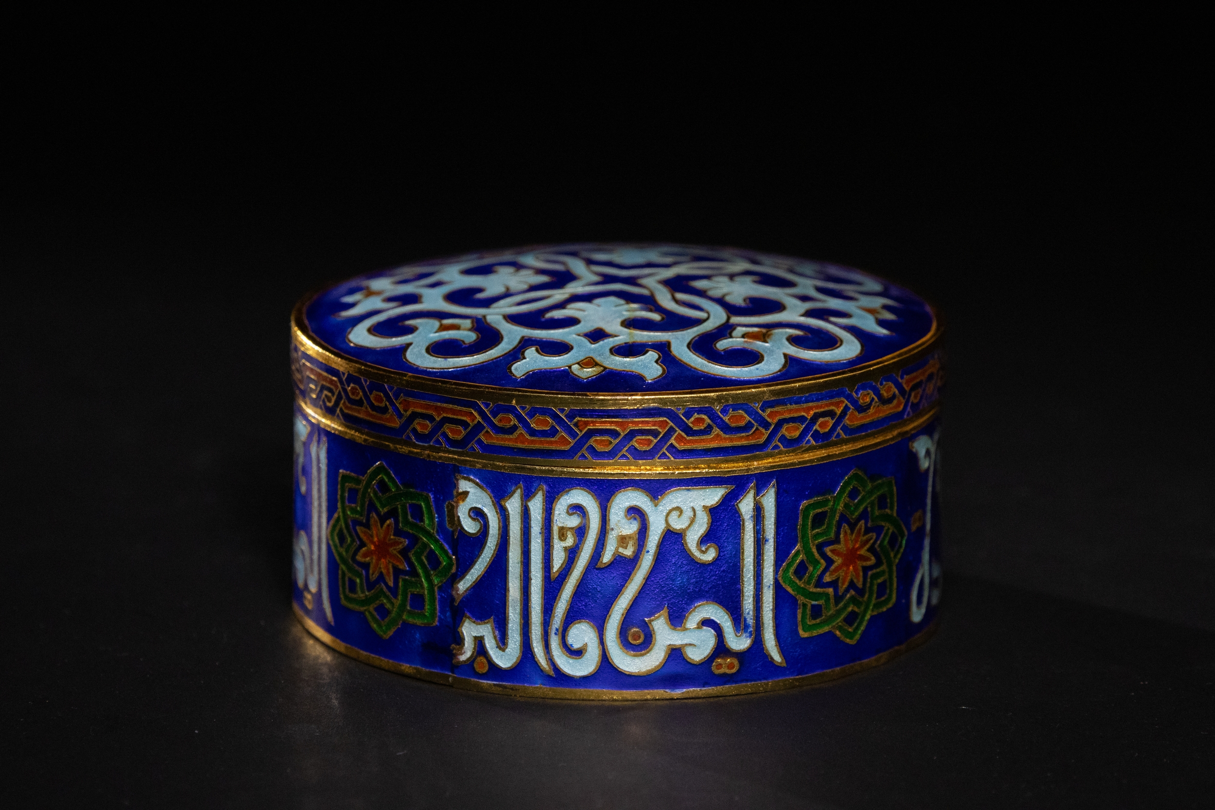 A MAMLUK STYLE ENAMELED CIRCULAR BOX WITH ARABIC CALLIGRAPHY.