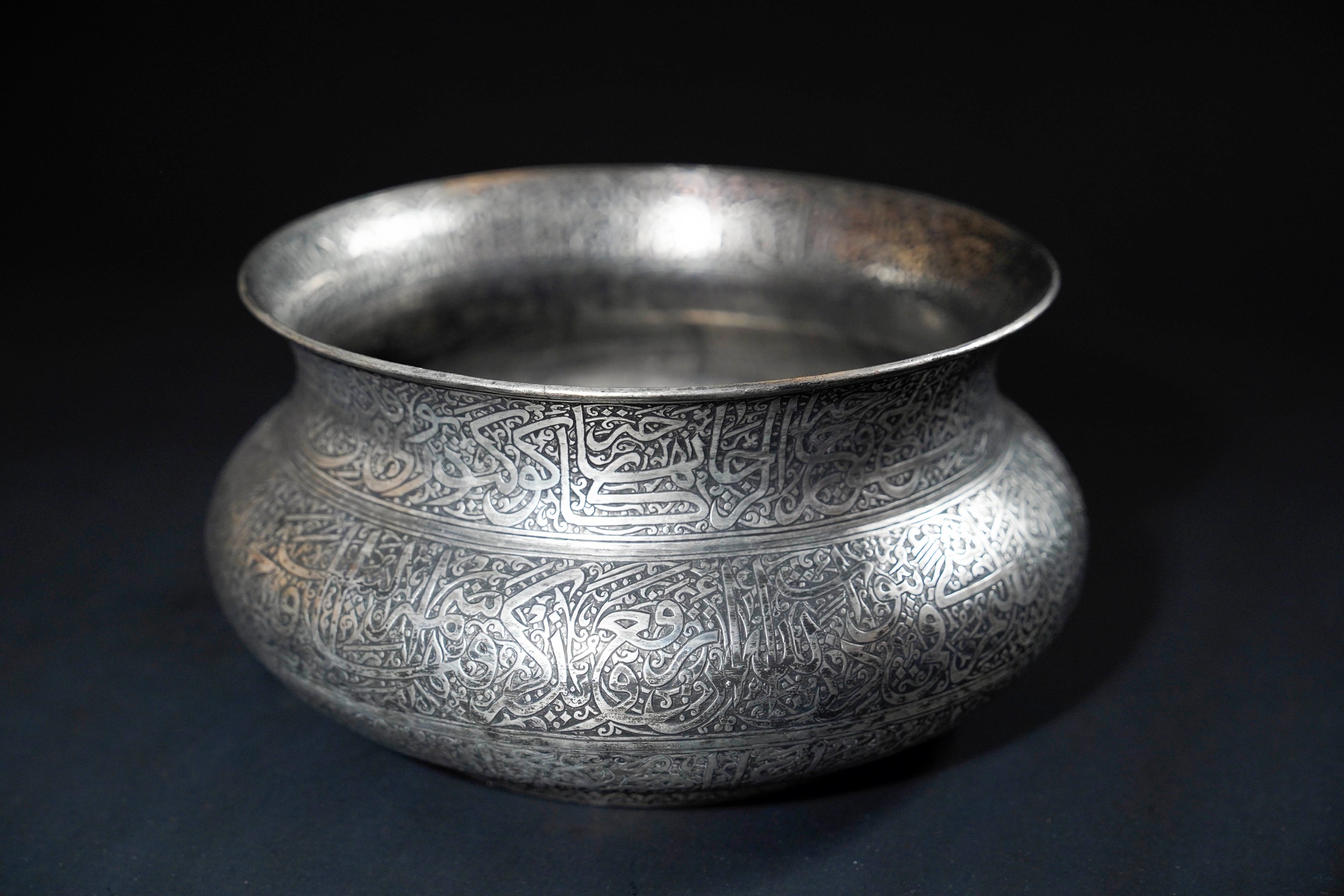 AN INDIAN DECCAN ENGRAVED COPPER KASHKUL BEGGAR'S BOWL, 17TH–18TH CENTURY.