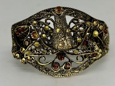 צמיד קפיצי מוזהב, מעוטר באבני חן, אליפטי, 6.5x4.1 ס״מ, גובה 5 ס״מ, חוסרים קלים