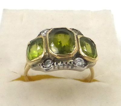 טבעת זהב 14K משובצת 4 יהלומים. 3-4 נק' כ"א, וכן שלושה פרידוטים, משקל ברוטו 7.1 גרם, מידה 55 (US 7.5)