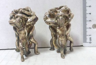 Pair of silver electroforming candlesticks. shaped like three puti, each holding a rose, 46 gm