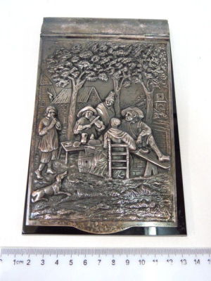 Notebook holder, silver plated plaque with hammered metal work, Dutch inn scene, Bakelite base