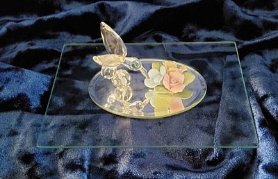 Crystal Hummingbird Figurine. Crystal hummingbird figurine taking nectar from multicolored 