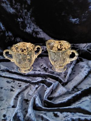 Glass creamer and sugar set with floral etching. Glass creamer and sugar bowl set featuring 
