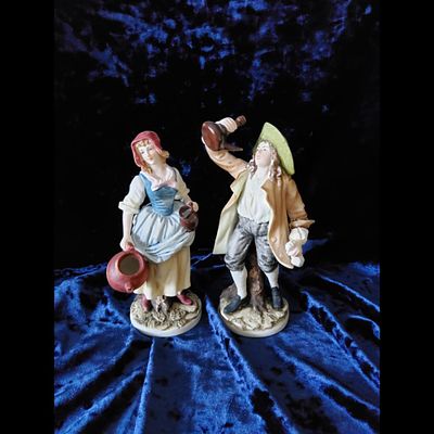 Figurines, Porcelain, Pair, Man, Woman. Porcelain figurines depict a man with a wine bottle and 