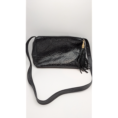 Black Leather Crossbody Bag with Tassel Accent. Description: Black leather crossbody bag with a 