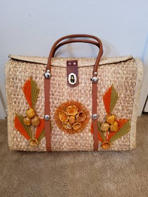 Woven Straw Bag with Leather Handles and Floral Accents. Woven straw bag featuring leather 