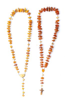 DUE ROSARI di cui uno in ambra e argento ed uno ambra e metallo (g. 210,77).