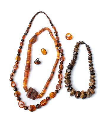 TRE COLLANE E TRE ANELLI in ambra di cui due in argento (g. 465) (rottura in un anello).